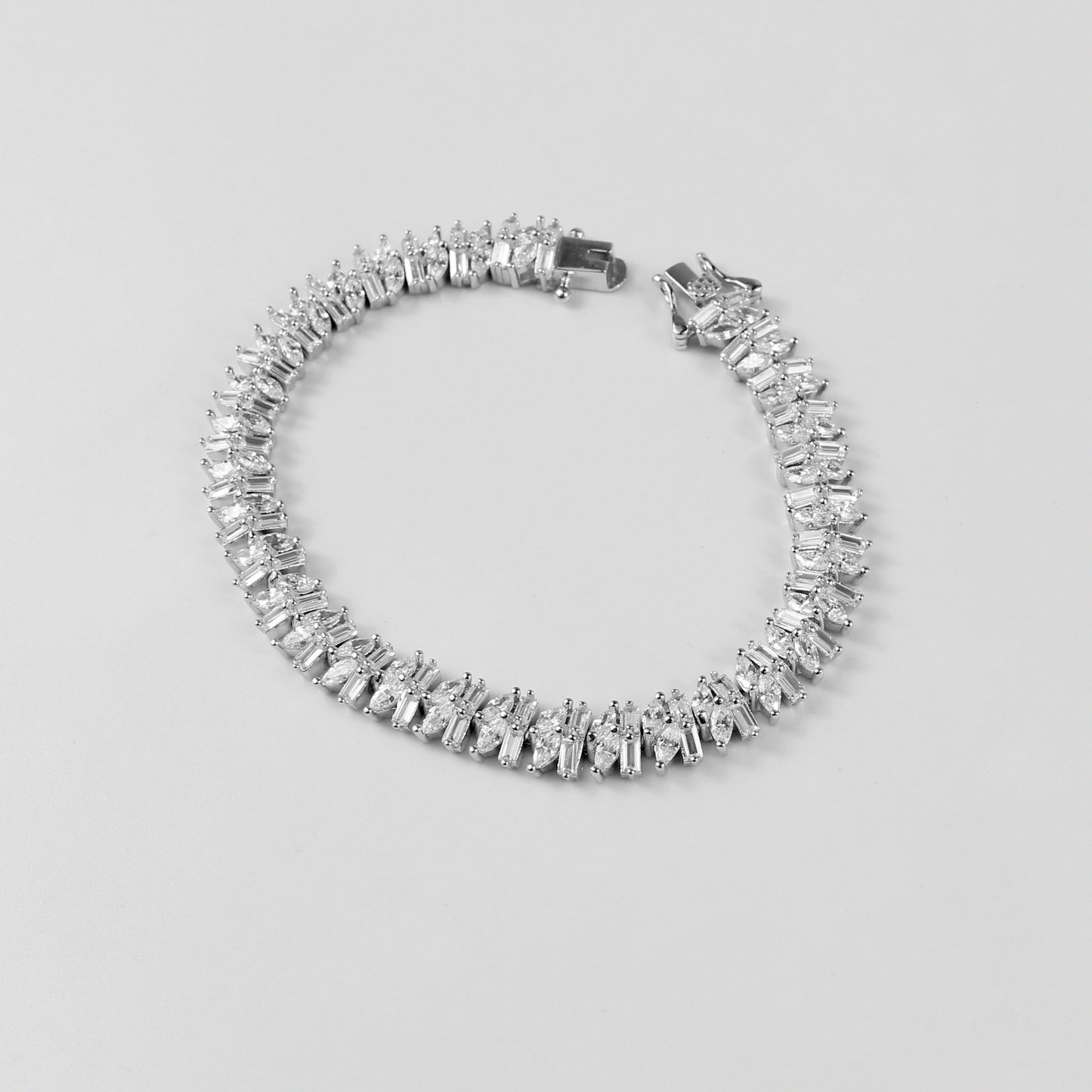 The 'Asymmetric Tennis' bracelet, crafted from 925 sterling silver, featuring a unique twist on the classic tennis bracelet design with asymmetrical detailing.