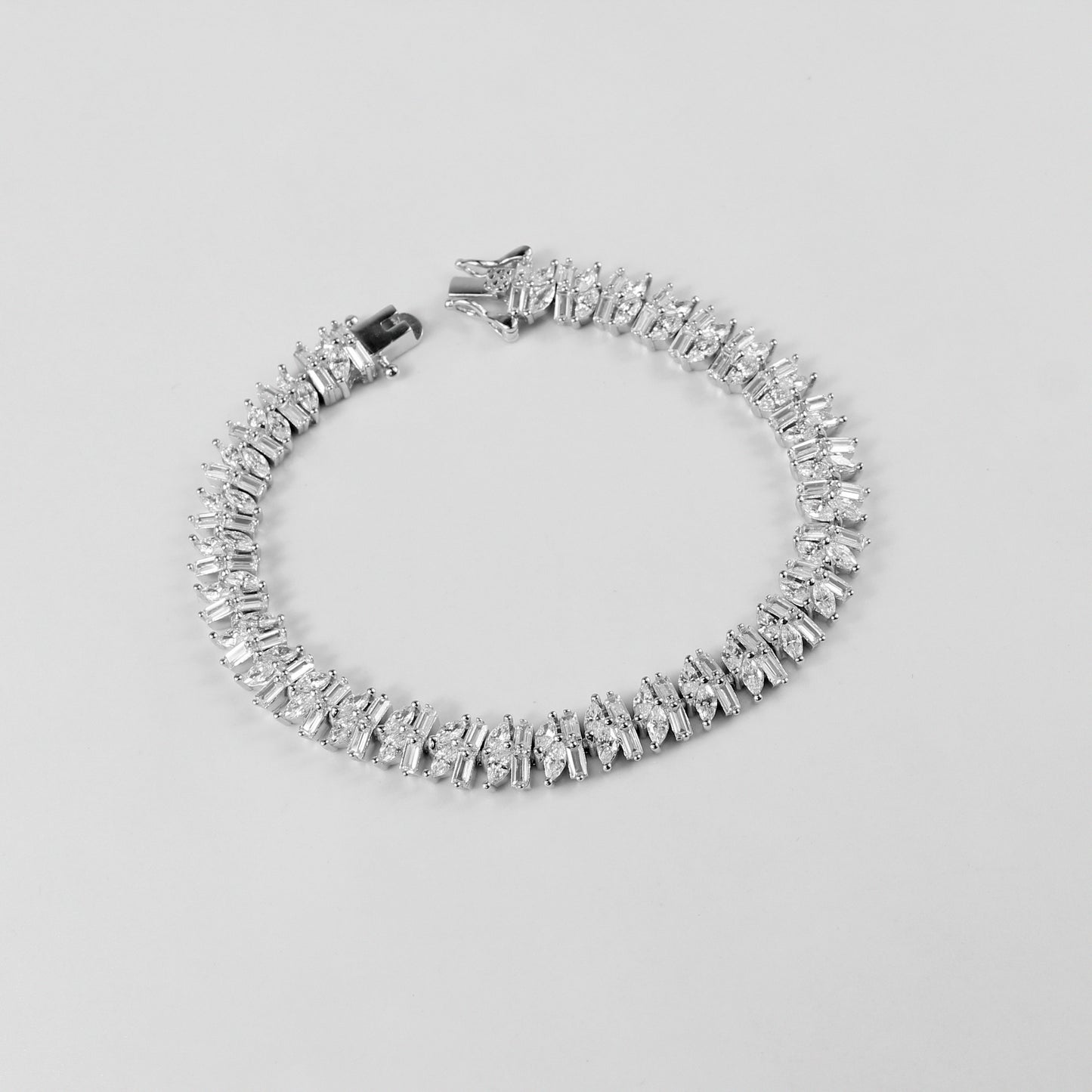 The 'Asymmetric Tennis' bracelet, crafted from 925 sterling silver, featuring a unique twist on the classic tennis bracelet design with asymmetrical detailing.