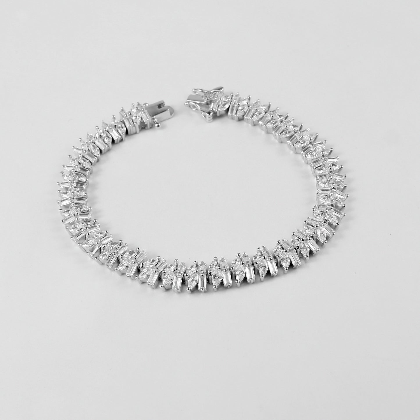 The 'Asymmetric Tennis' bracelet, crafted from 925 sterling silver, featuring a unique twist on the classic tennis bracelet design with asymmetrical detailing.