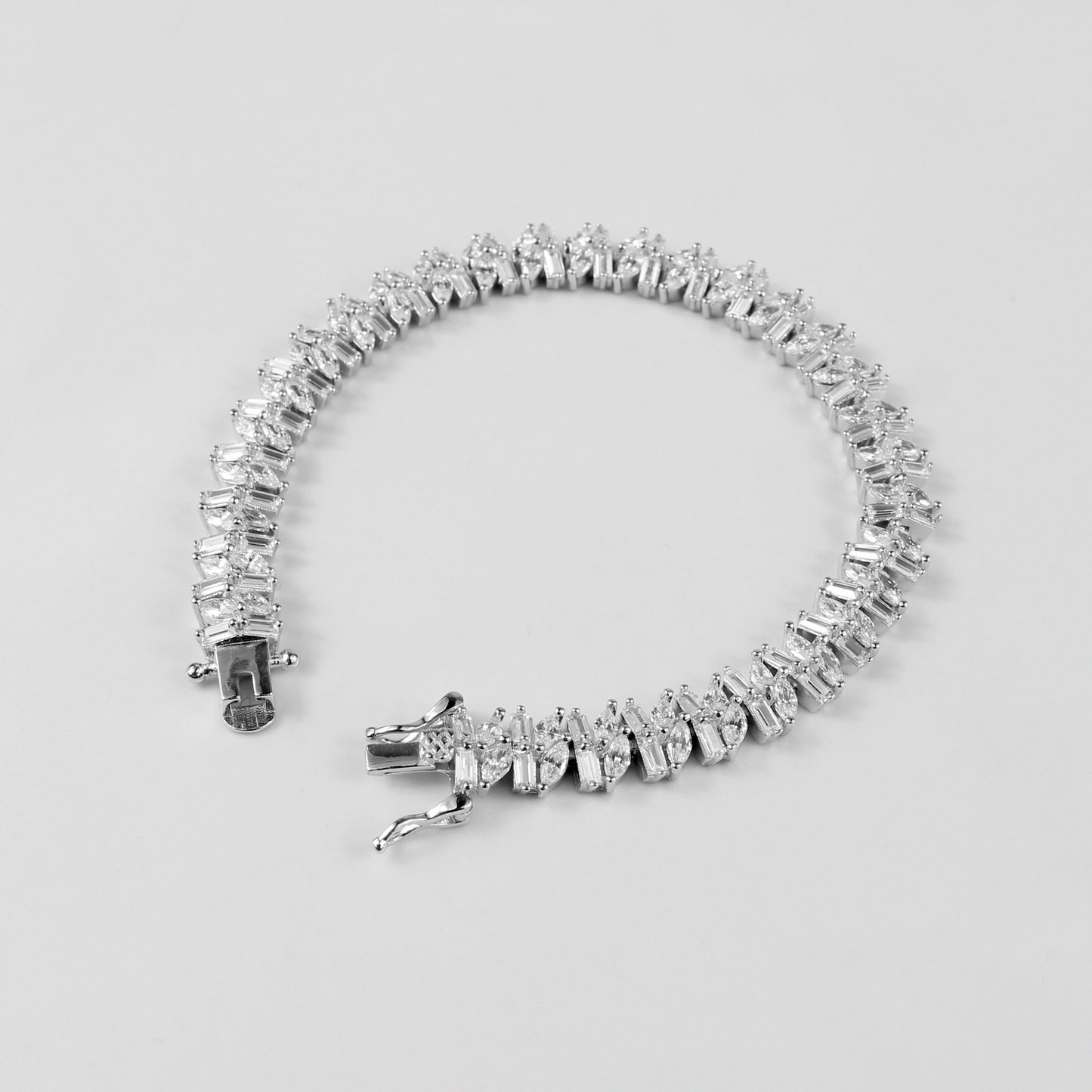 The 'Asymmetric Tennis' bracelet, crafted from 925 sterling silver, featuring a unique twist on the classic tennis bracelet design with asymmetrical detailing.