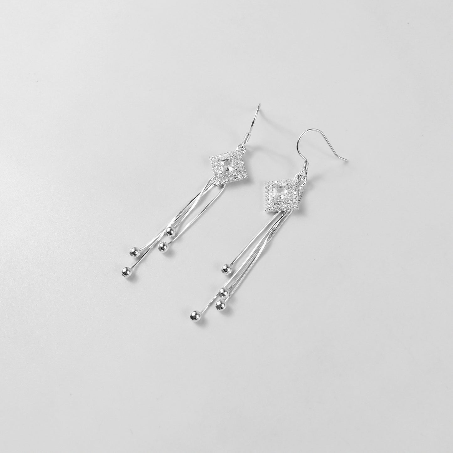 A pair of exquisite 925 sterling silver earrings with a celestial theme. The design features delicate droplets that cascade like a gentle drizzle, capturing the ethereal beauty of starlit skies. A perfect accessory to add a touch of elegance and whimsy to any outfit.