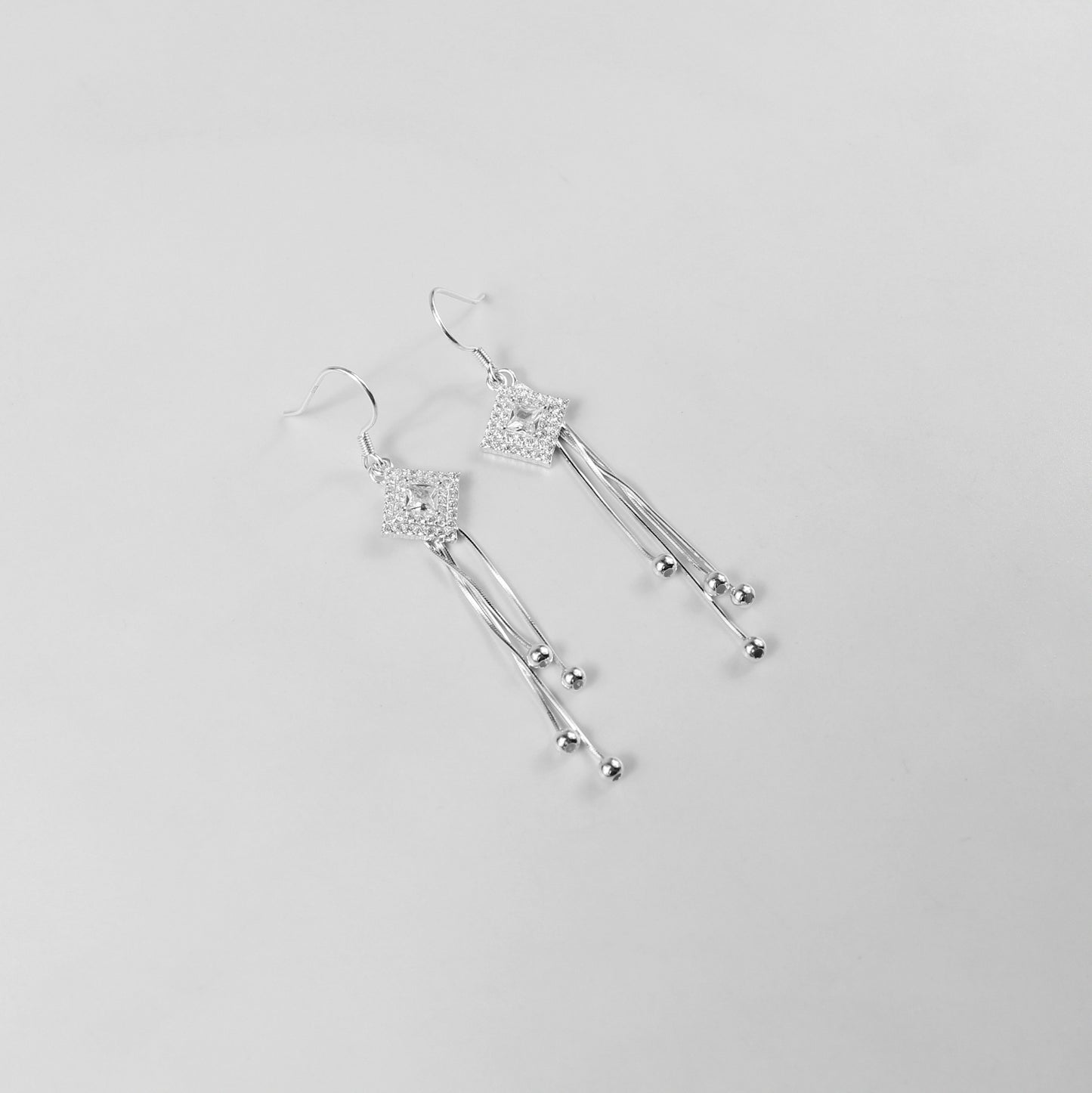 A pair of exquisite 925 sterling silver earrings with a celestial theme. The design features delicate droplets that cascade like a gentle drizzle, capturing the ethereal beauty of starlit skies. A perfect accessory to add a touch of elegance and whimsy to any outfit.