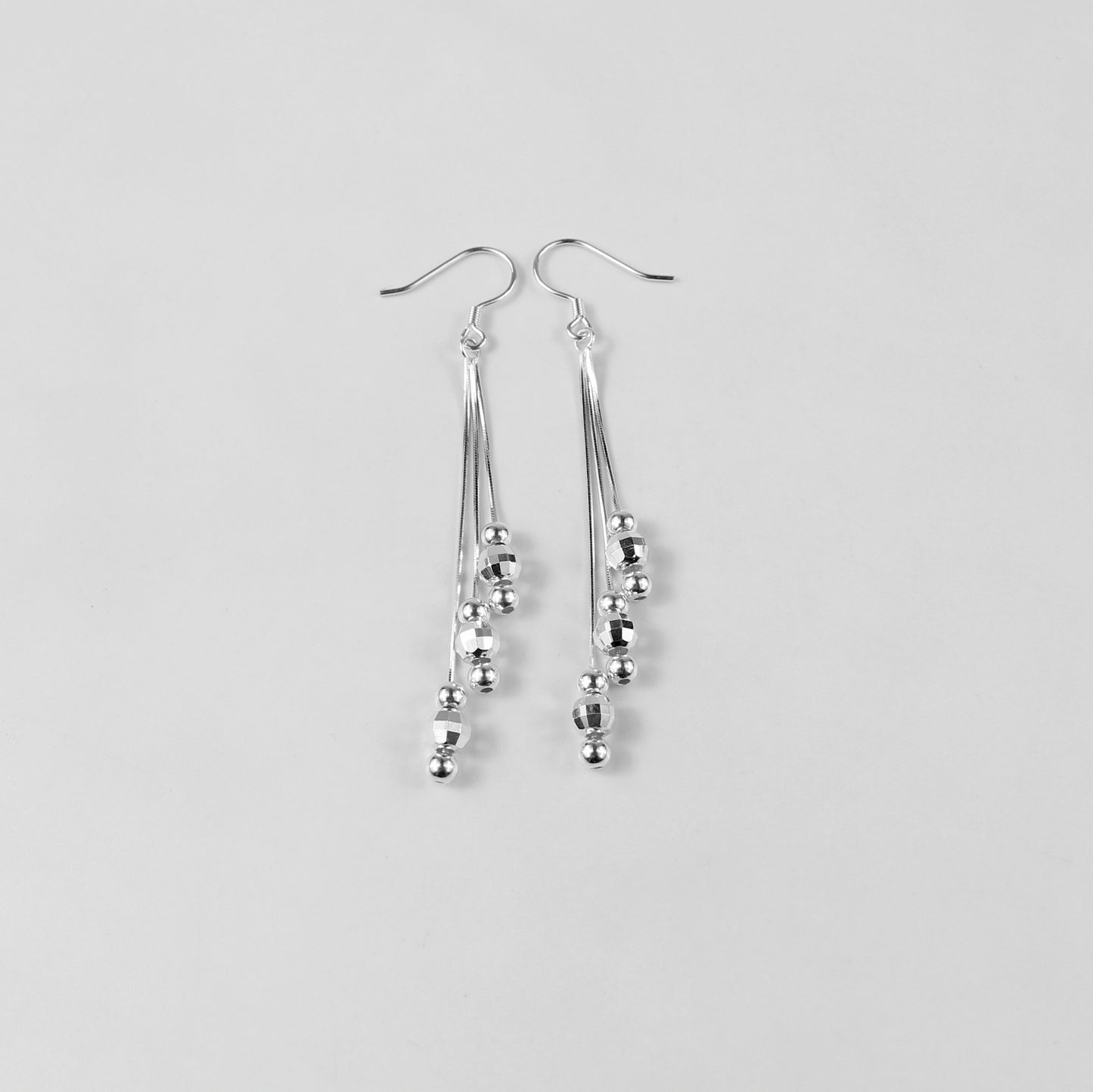 A pair of elegant tassel earrings crafted from 925 sterling silver. The design features delicate strands that shimmer with a moonlit silver finish, evoking a celestial and sophisticated aesthetic. Perfect for formal or evening wear.