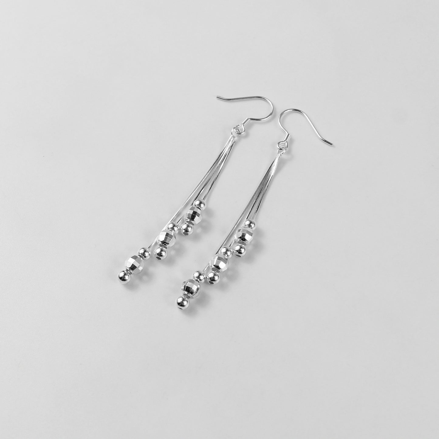 A pair of elegant tassel earrings crafted from 925 sterling silver. The design features delicate strands that shimmer with a moonlit silver finish, evoking a celestial and sophisticated aesthetic. Perfect for formal or evening wear.
