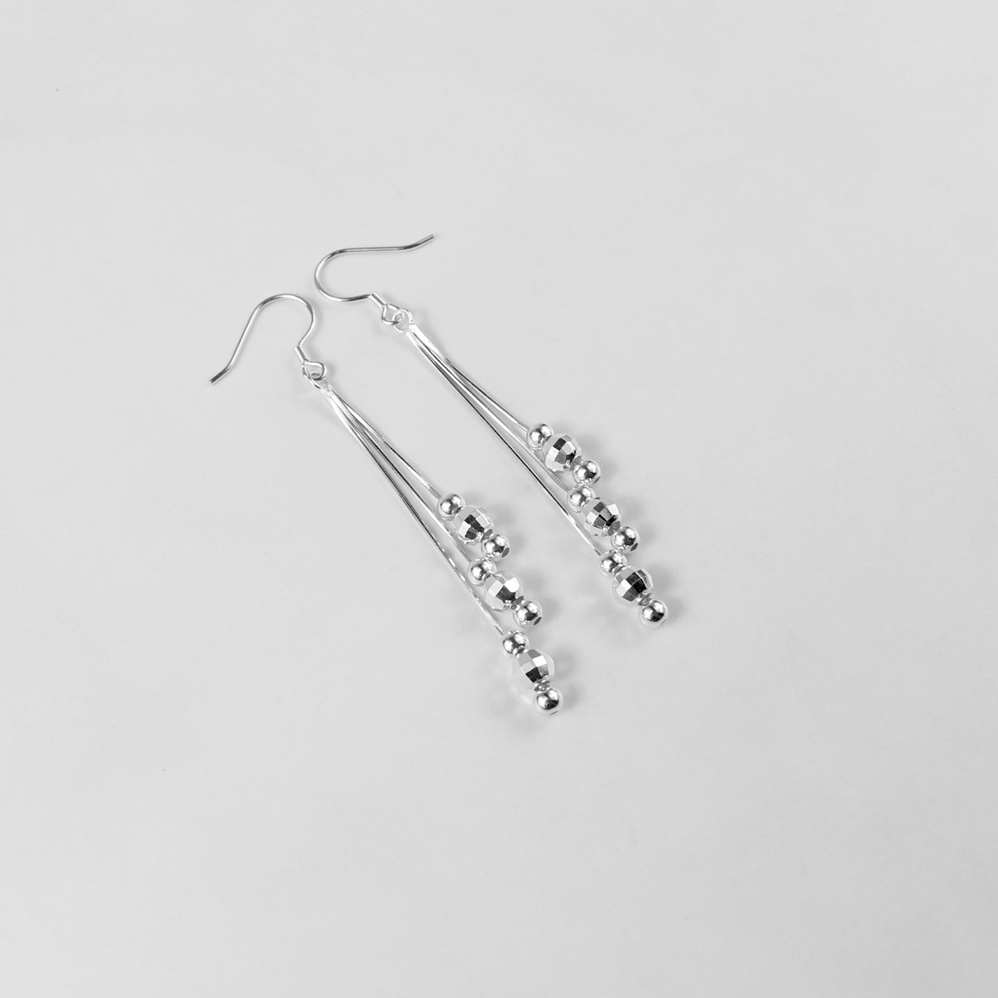 A pair of elegant tassel earrings crafted from 925 sterling silver. The design features delicate strands that shimmer with a moonlit silver finish, evoking a celestial and sophisticated aesthetic. Perfect for formal or evening wear.
