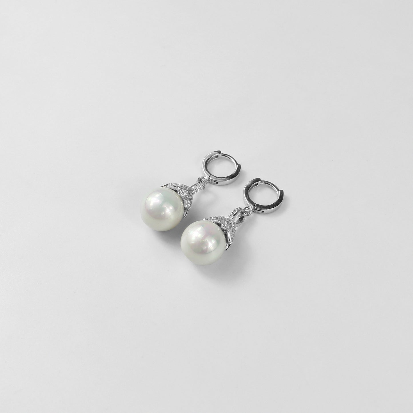 A pair of dazzling 925 sterling silver ear studs featuring radiant pearls that evoke the beauty of an aurora. The design captures a sense of elegance and ethereal charm, making these studs a striking accessory for any occasion.