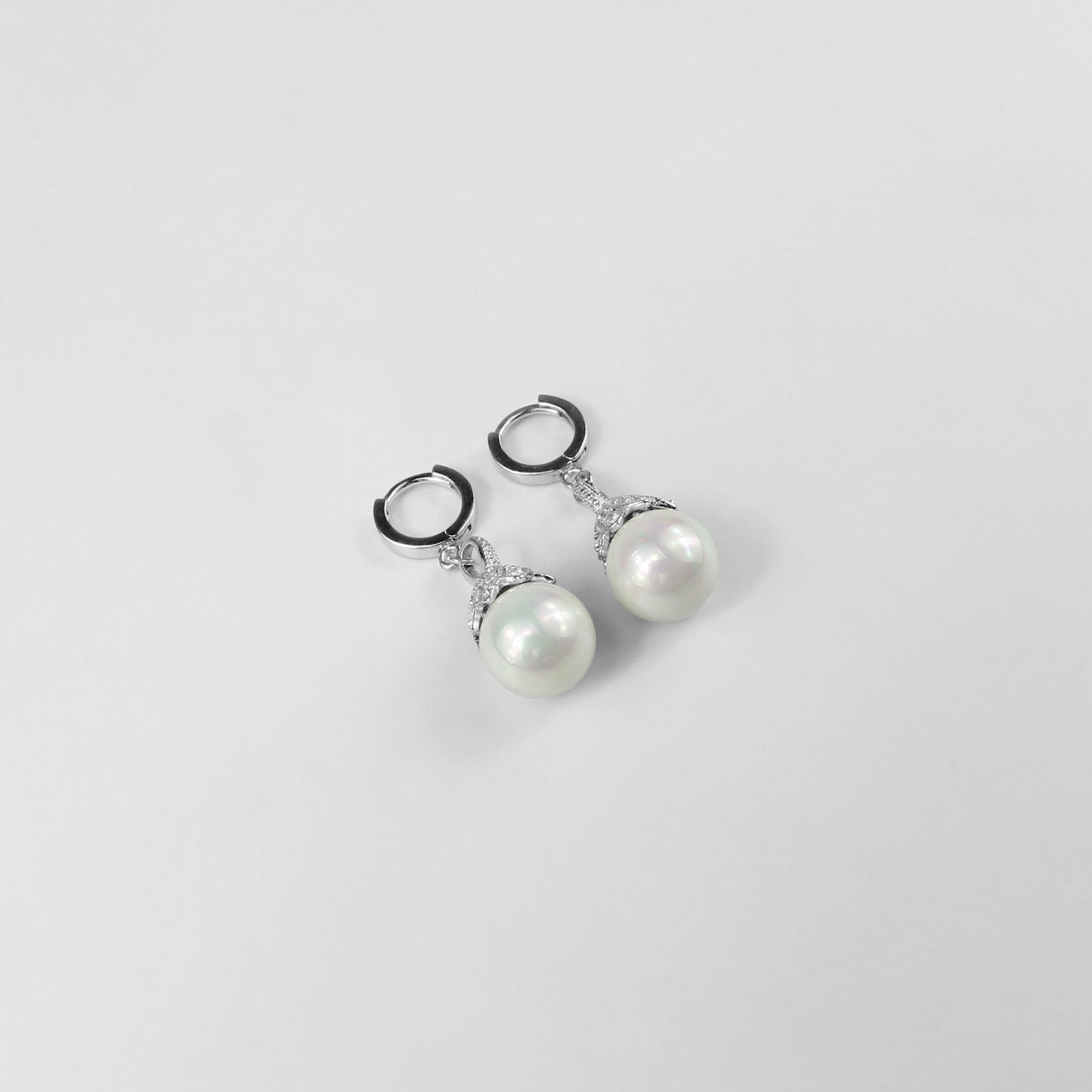 A pair of dazzling 925 sterling silver ear studs featuring radiant pearls that evoke the beauty of an aurora. The design captures a sense of elegance and ethereal charm, making these studs a striking accessory for any occasion.