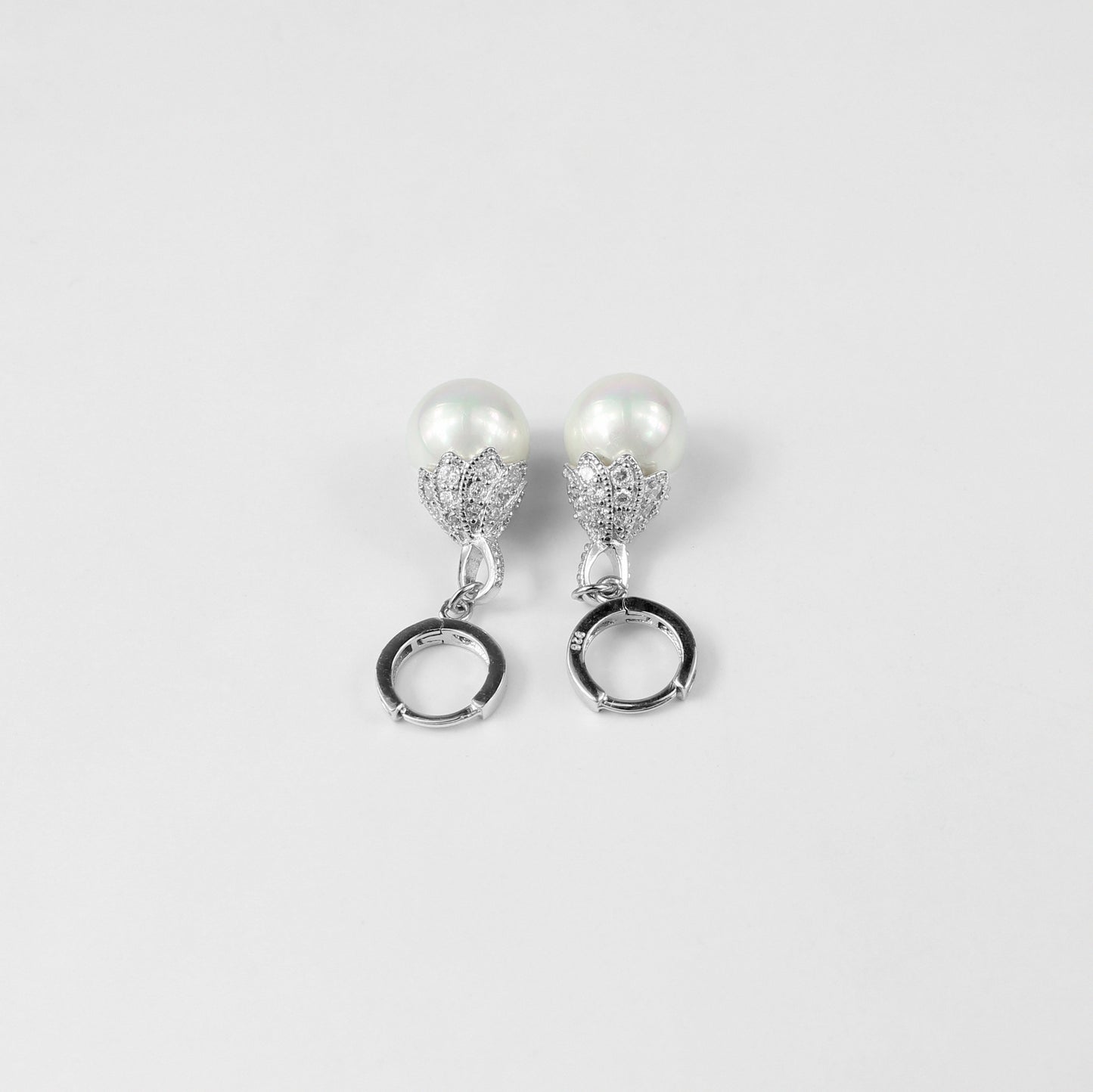 A pair of dazzling 925 sterling silver ear studs featuring radiant pearls that evoke the beauty of an aurora. The design captures a sense of elegance and ethereal charm, making these studs a striking accessory for any occasion.