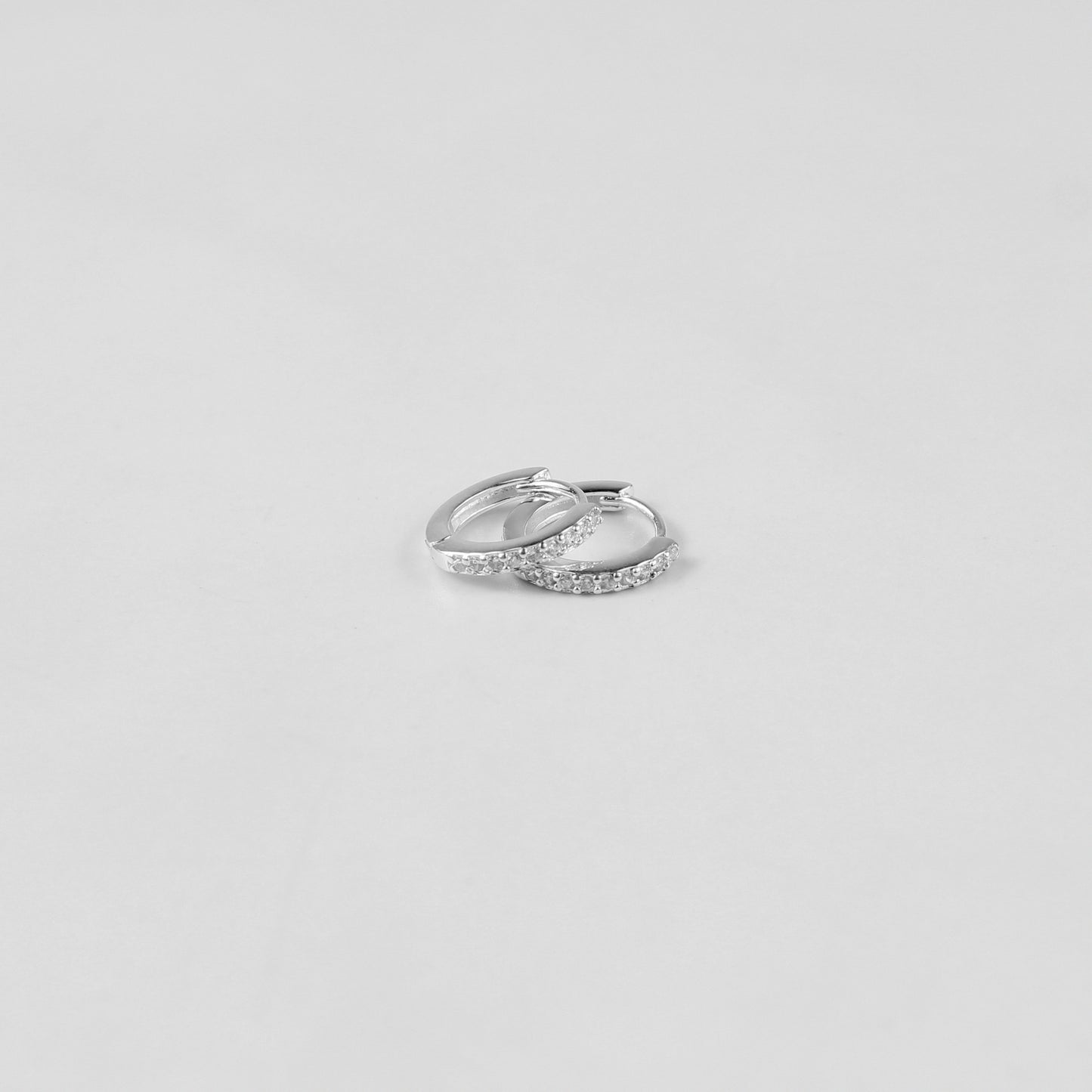 Elegant crystal halo ear studs crafted from 925 sterling silver, showcased on a white surface. The shimmering crystals catch the light beautifully, enhancing their sophisticated design.