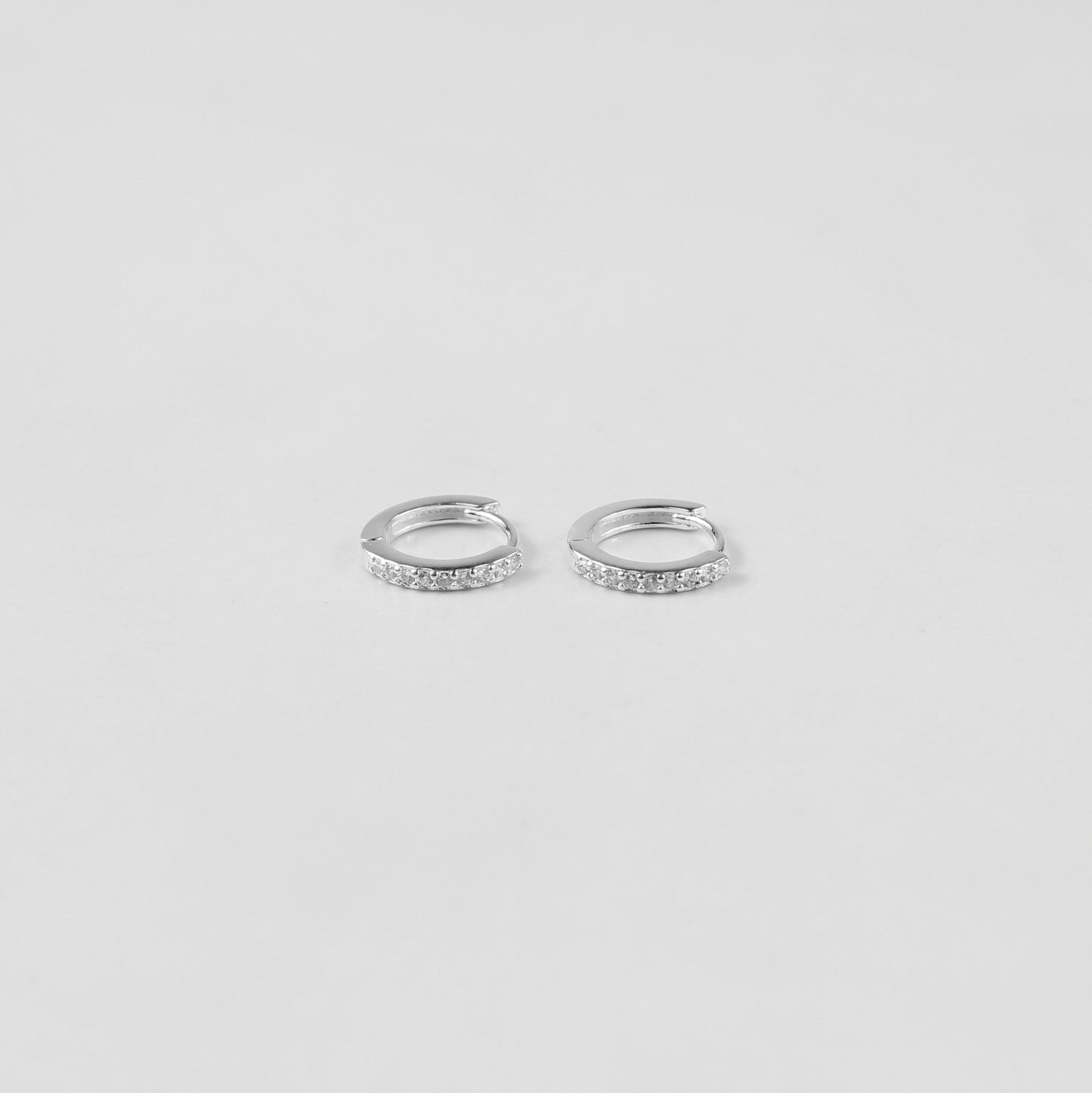 Elegant crystal halo ear studs crafted from 925 sterling silver, showcased on a white surface. The shimmering crystals catch the light beautifully, enhancing their sophisticated design.