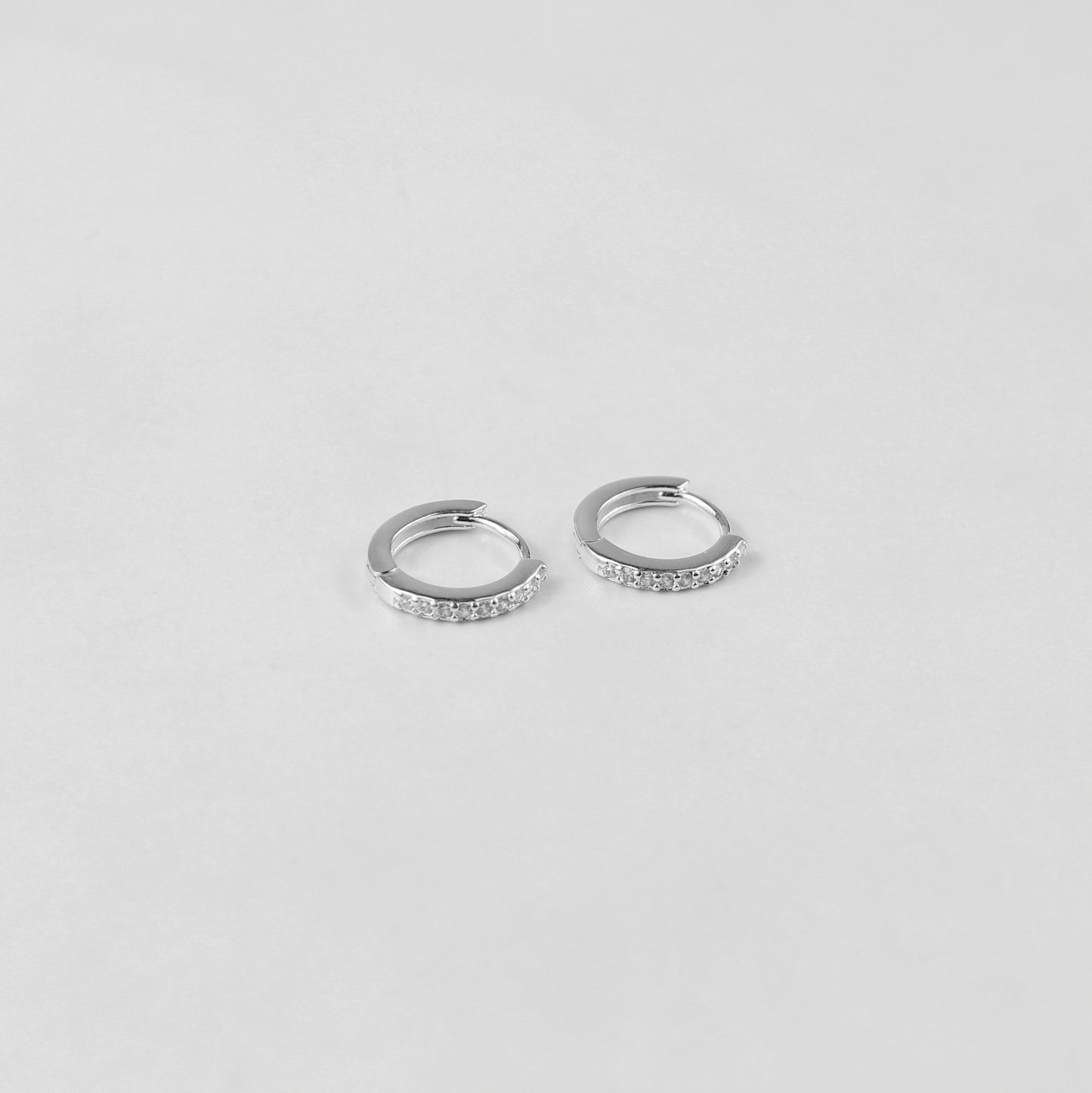 Elegant crystal halo ear studs crafted from 925 sterling silver, showcased on a white surface. The shimmering crystals catch the light beautifully, enhancing their sophisticated design.
