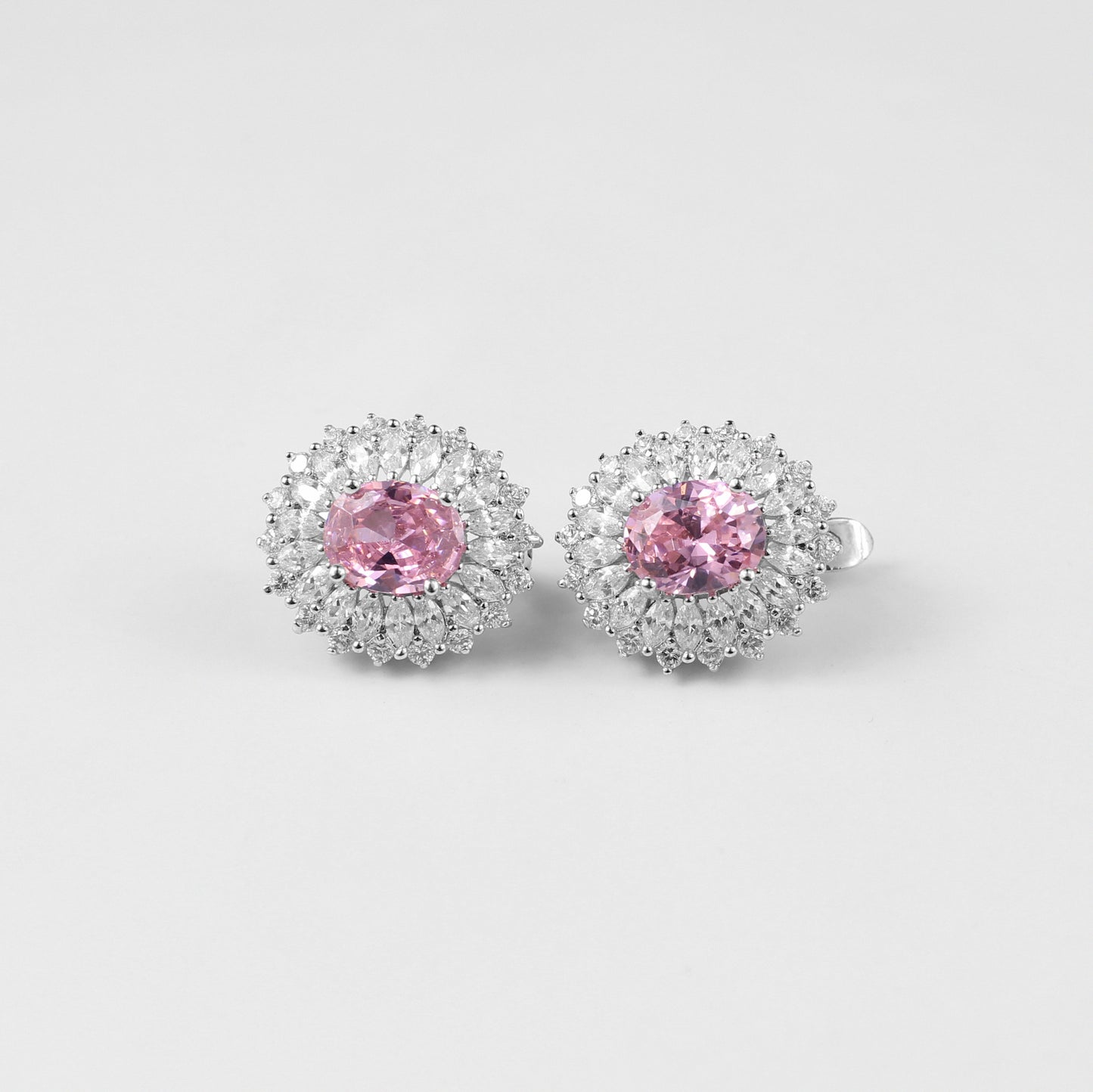 A pair of sophisticated 925 sterling silver ear studs featuring soft pink accents set in a sleek, orbital design. These studs combine modern elegance with a touch of feminine charm, perfect for adding subtle color and style to any look.