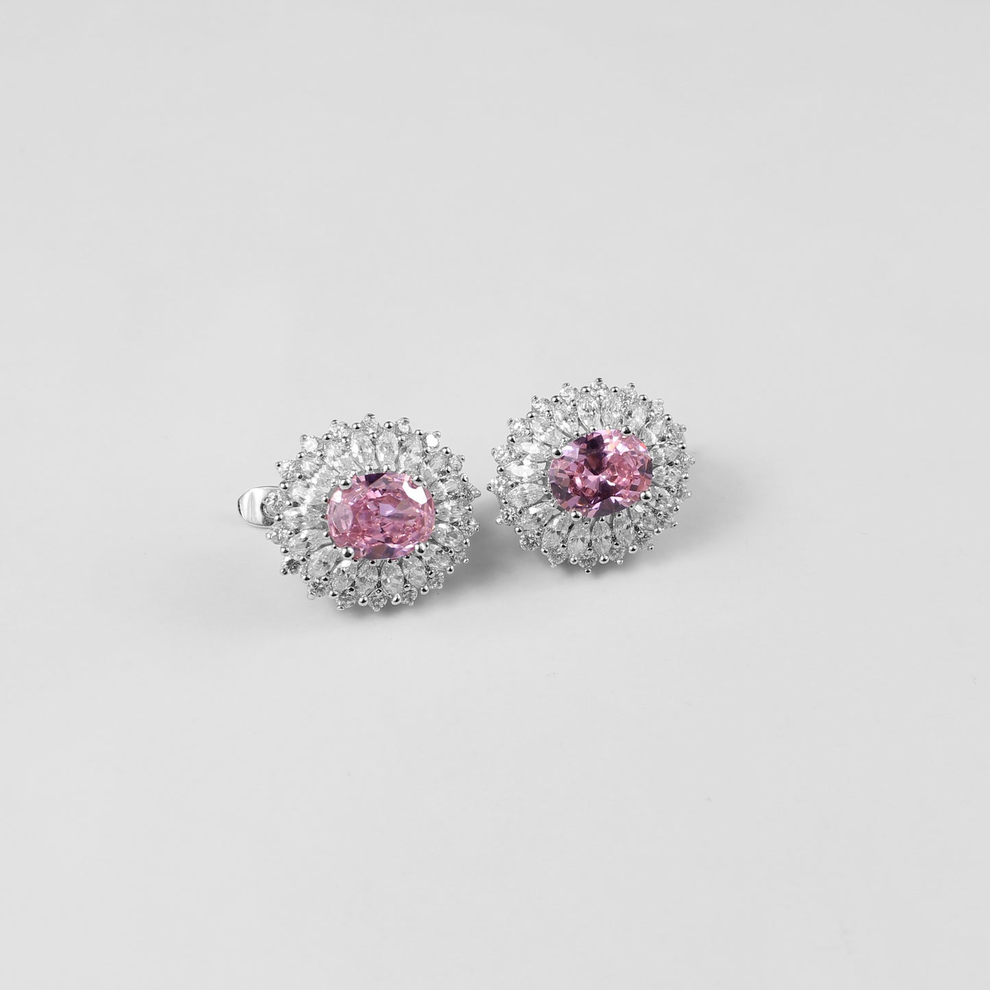 A pair of sophisticated 925 sterling silver ear studs featuring soft pink accents set in a sleek, orbital design. These studs combine modern elegance with a touch of feminine charm, perfect for adding subtle color and style to any look.