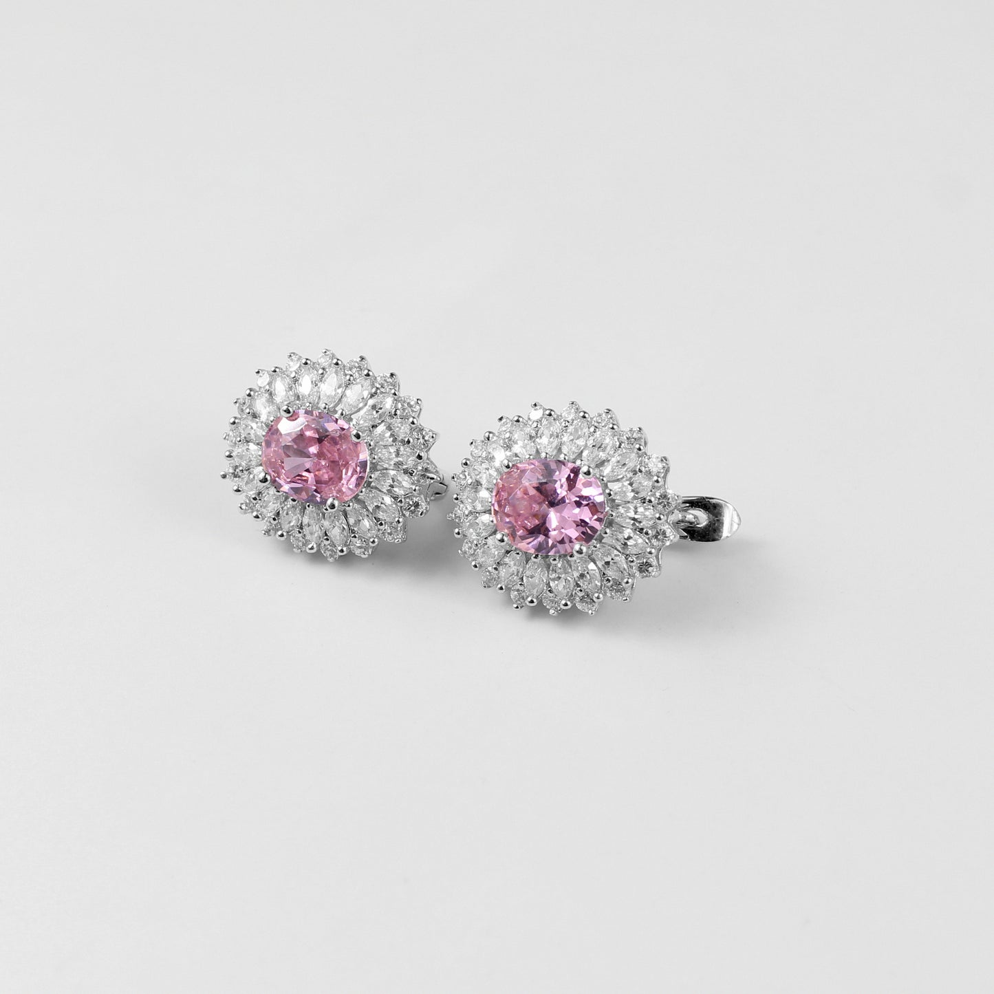A pair of sophisticated 925 sterling silver ear studs featuring soft pink accents set in a sleek, orbital design. These studs combine modern elegance with a touch of feminine charm, perfect for adding subtle color and style to any look.
