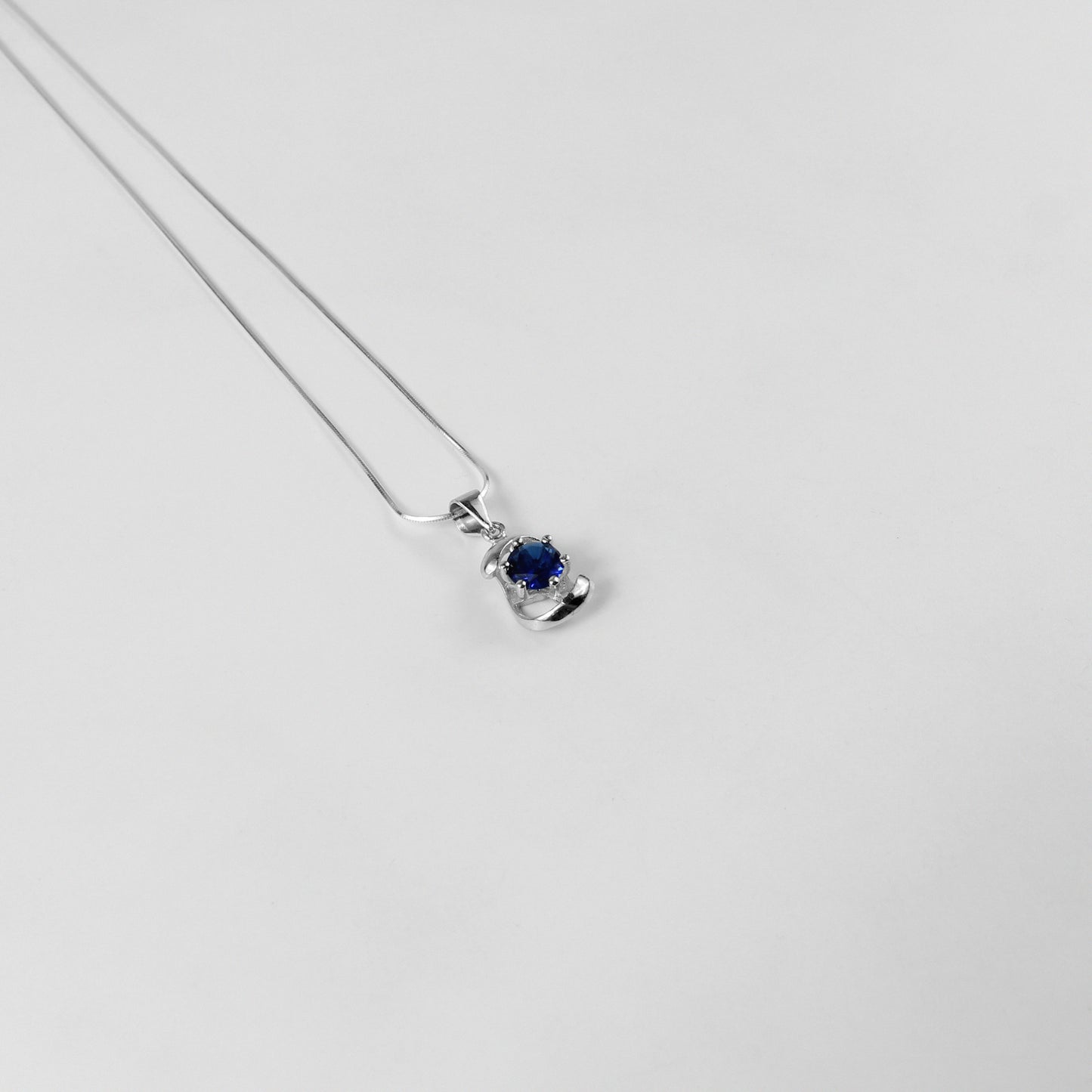 A striking necklace named 'Blue Echo,' crafted from 925 sterling silver. Its design features vibrant blue accents, evoking a sense of calm and sophistication with a modern edge.