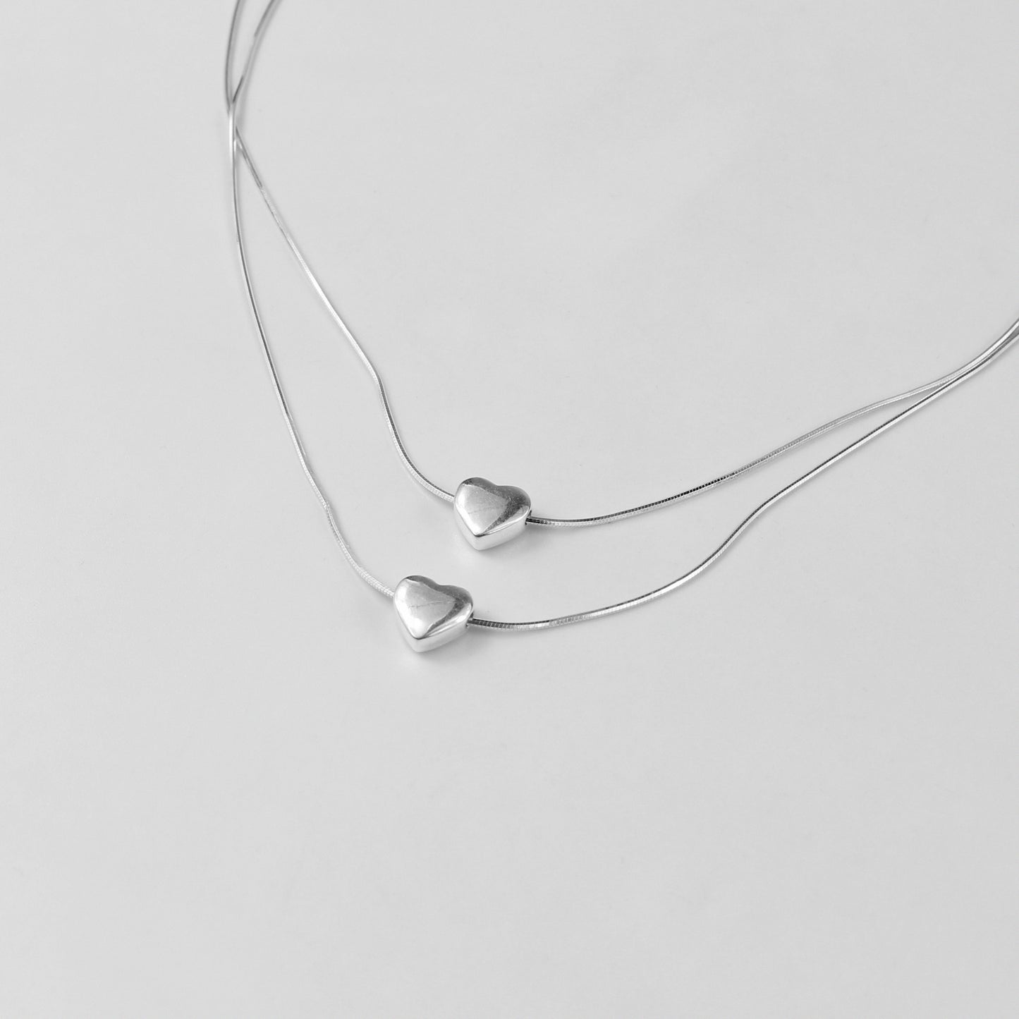 An exquisite necklace named 'Eternal Heartstrings,' crafted from 925 sterling silver. Its design features intertwining heart motifs, symbolizing everlasting love and connection with a refined elegance.