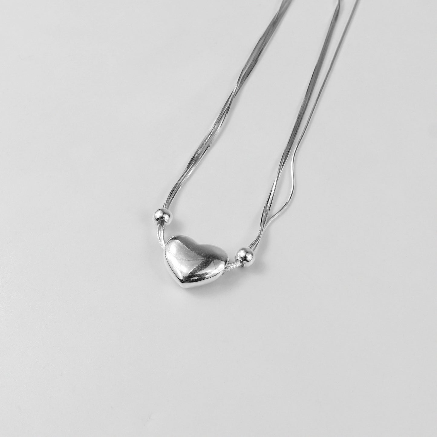 An elegant necklace named 'Heartstrings,' crafted from 925 sterling silver. Its design features delicate, intertwining strands that symbolize connection, love, and timeless beauty.
