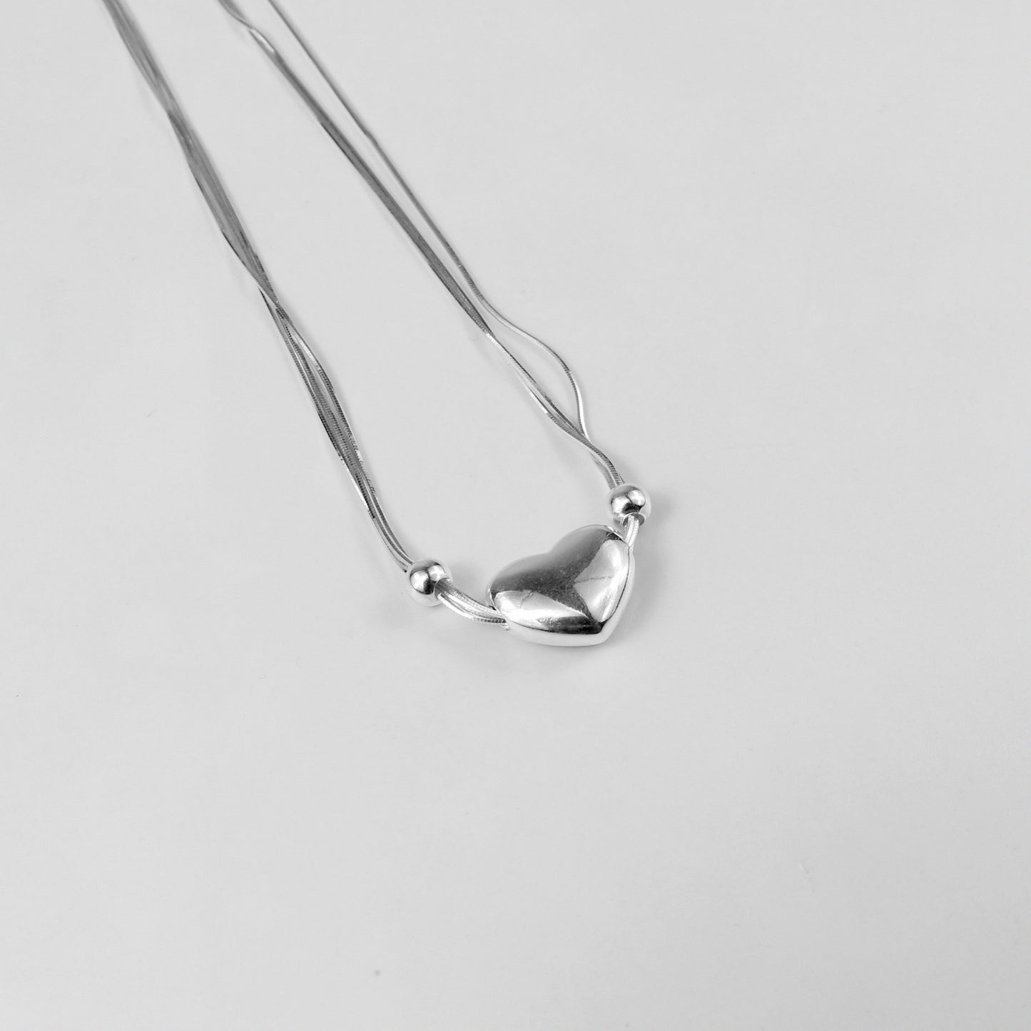 An elegant necklace named 'Heartstrings,' crafted from 925 sterling silver. Its design features delicate, intertwining strands that symbolize connection, love, and timeless beauty.