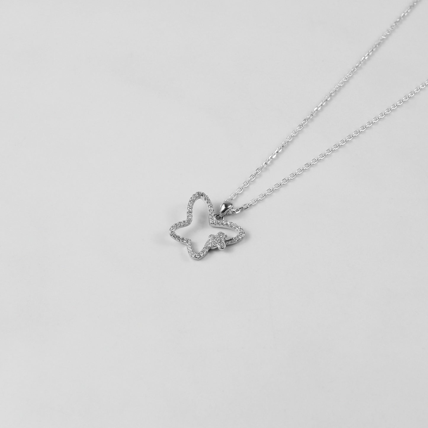 GETTHEJUICE-925STERLINGSILVER-Moonlit Flutter Necklace: A sterling silver necklace featuring a delicate butterfly charm with a moonlit glow, exuding elegance and grace.