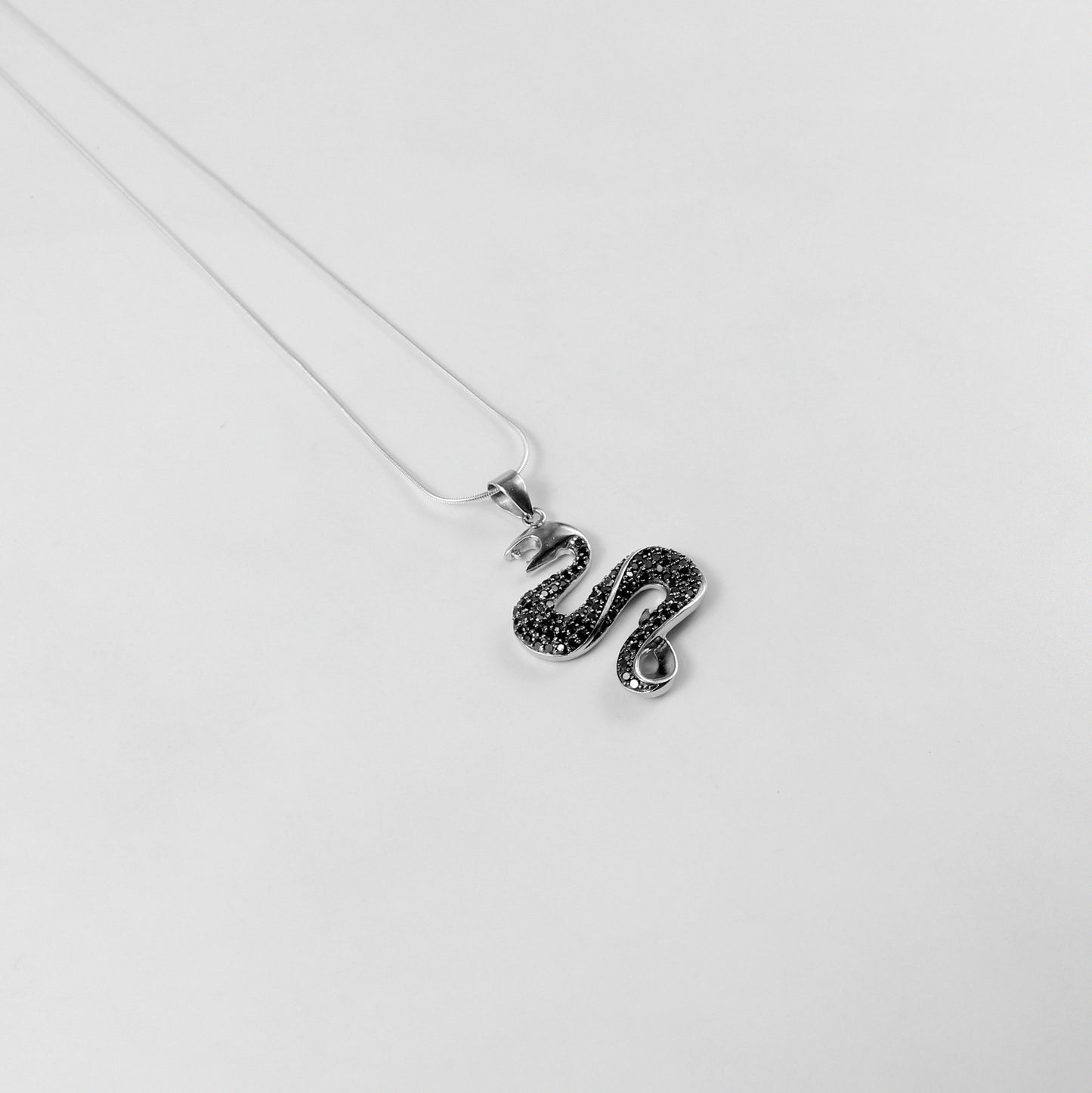 925 sterling silver necklace named 'Shadow Serpent,' featuring a sleek and sinuous design inspired by the graceful yet mysterious movement of a serpent. Its bold and enigmatic craftsmanship exudes a striking balance of elegance and edge, perfect for making a statement.