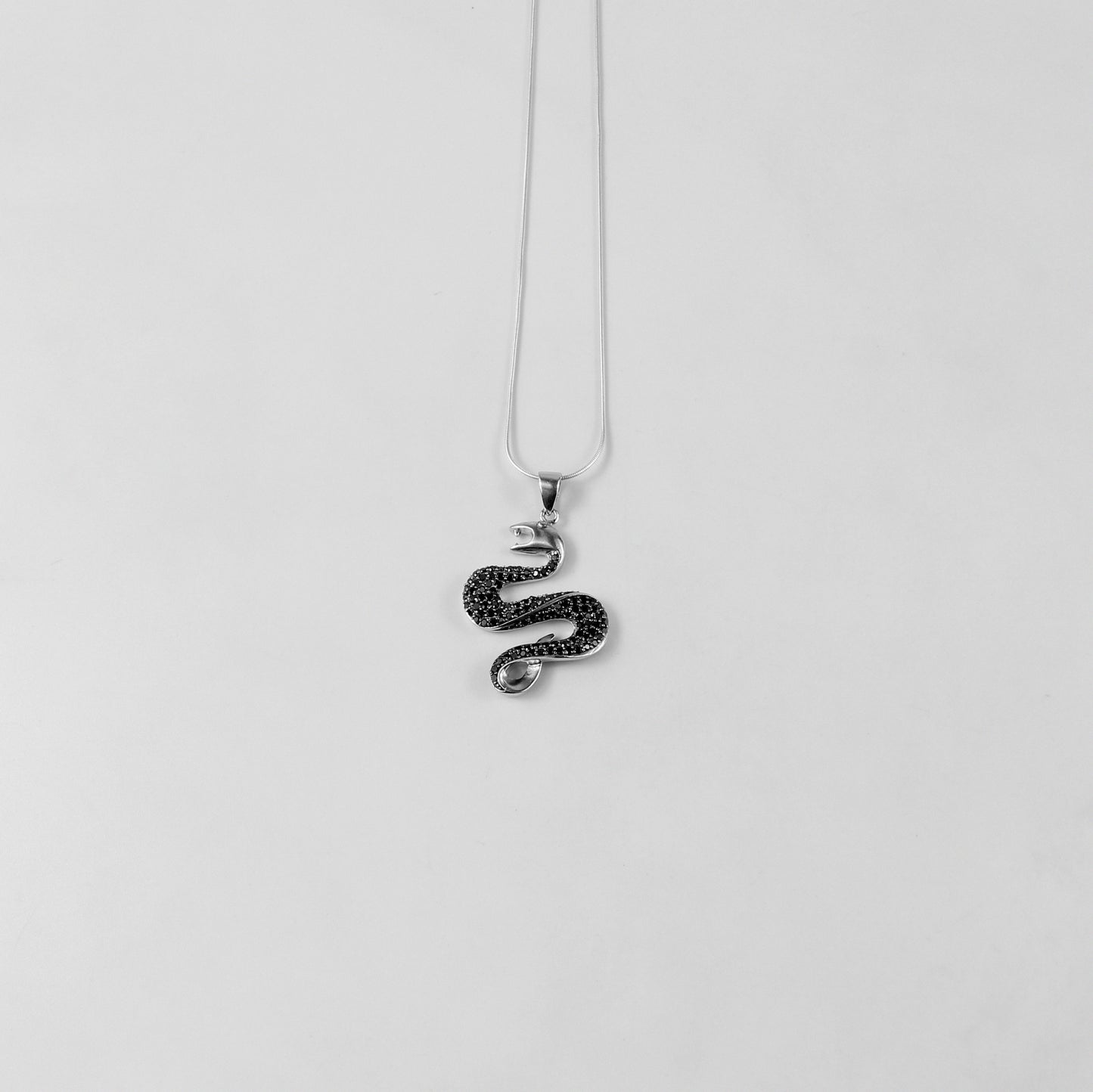 925 sterling silver necklace named 'Shadow Serpent,' featuring a sleek and sinuous design inspired by the graceful yet mysterious movement of a serpent. Its bold and enigmatic craftsmanship exudes a striking balance of elegance and edge, perfect for making a statement.