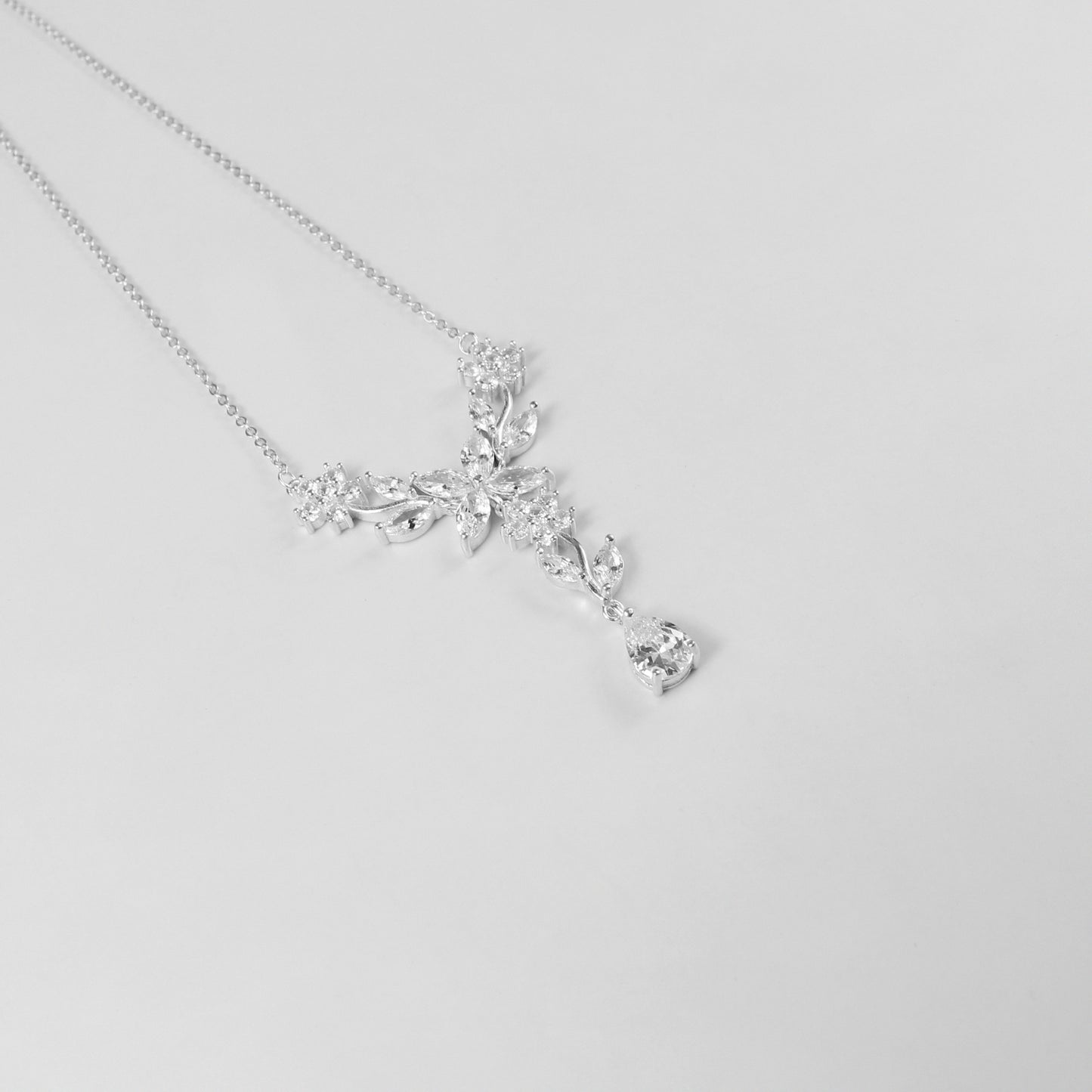 A delicate necklace featuring a floral-inspired design, crafted from 925 sterling silver, named 'Shimmer Bloom.' Its intricate detailing and elegant shimmer create a timeless and sophisticated accessory.