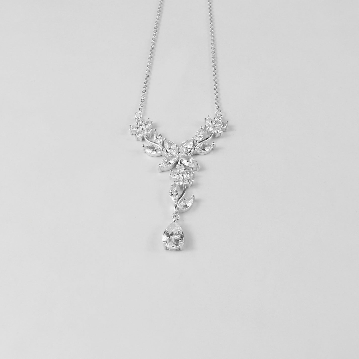 A delicate necklace featuring a floral-inspired design, crafted from 925 sterling silver, named 'Shimmer Bloom.' Its intricate detailing and elegant shimmer create a timeless and sophisticated accessory.
