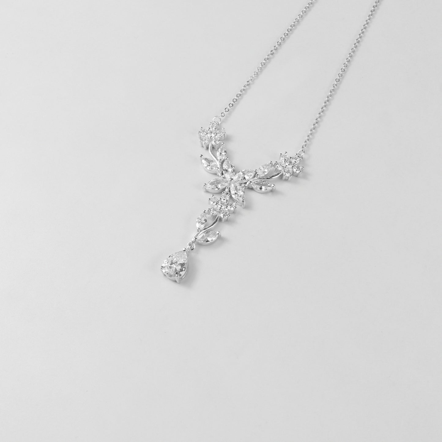 A delicate necklace featuring a floral-inspired design, crafted from 925 sterling silver, named 'Shimmer Bloom.' Its intricate detailing and elegant shimmer create a timeless and sophisticated accessory.