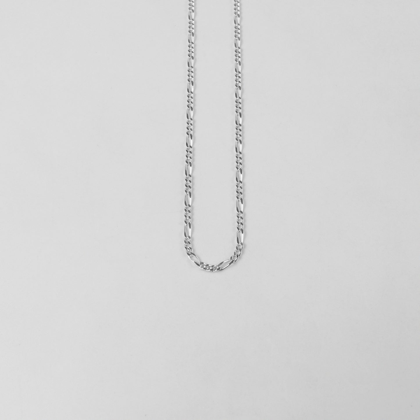 925 sterling silver necklace named 'Thin Figaro,' featuring a classic and delicate chain design with alternating short and long links. Its timeless elegance and understated sophistication make it a versatile accessory for any outfit or occasion.