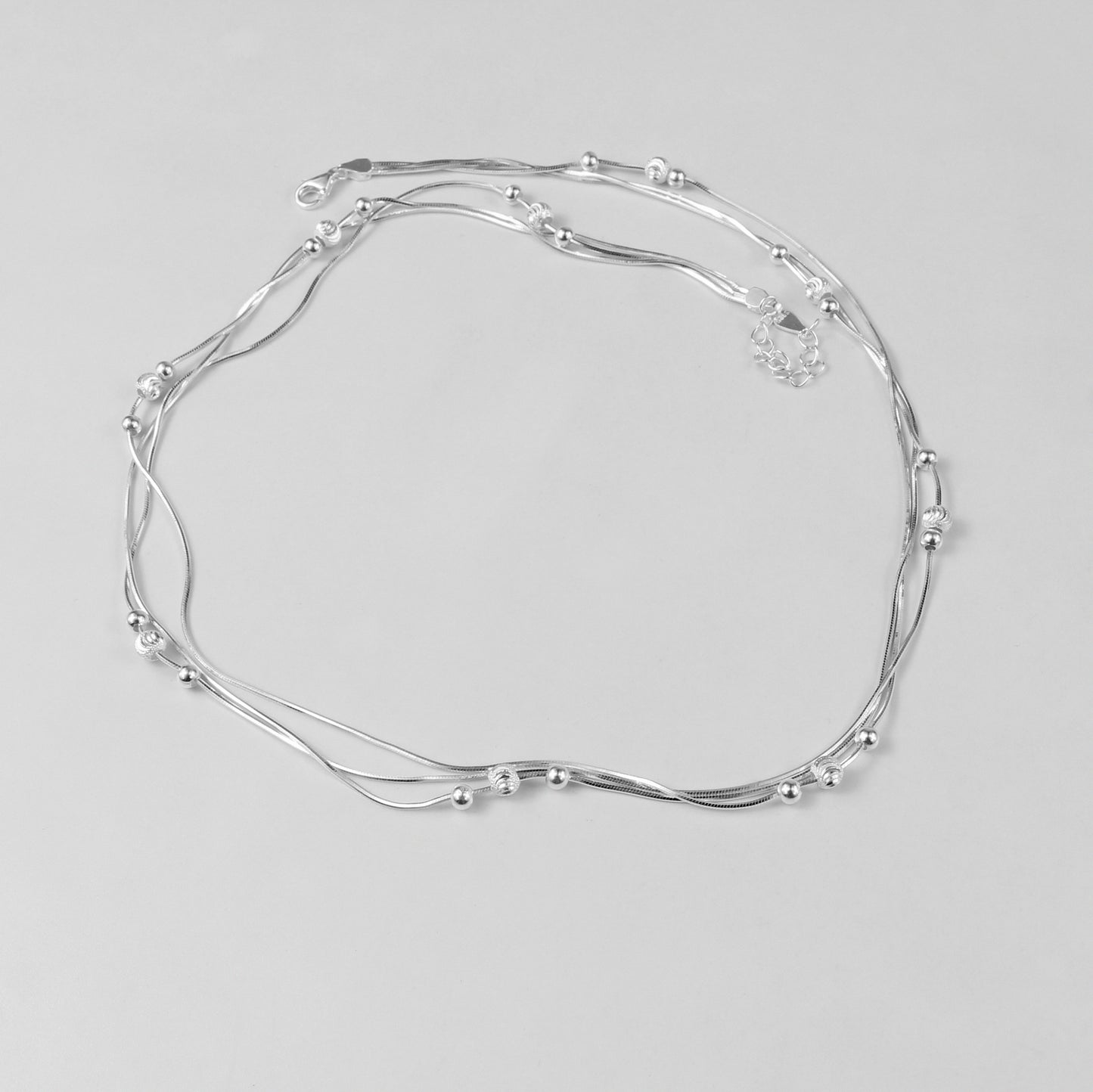An elegant necklace named 'Trio Shine,' crafted from 925 sterling silver. Its design features three radiant elements that symbolize harmony, brilliance, and timeless sophistication.