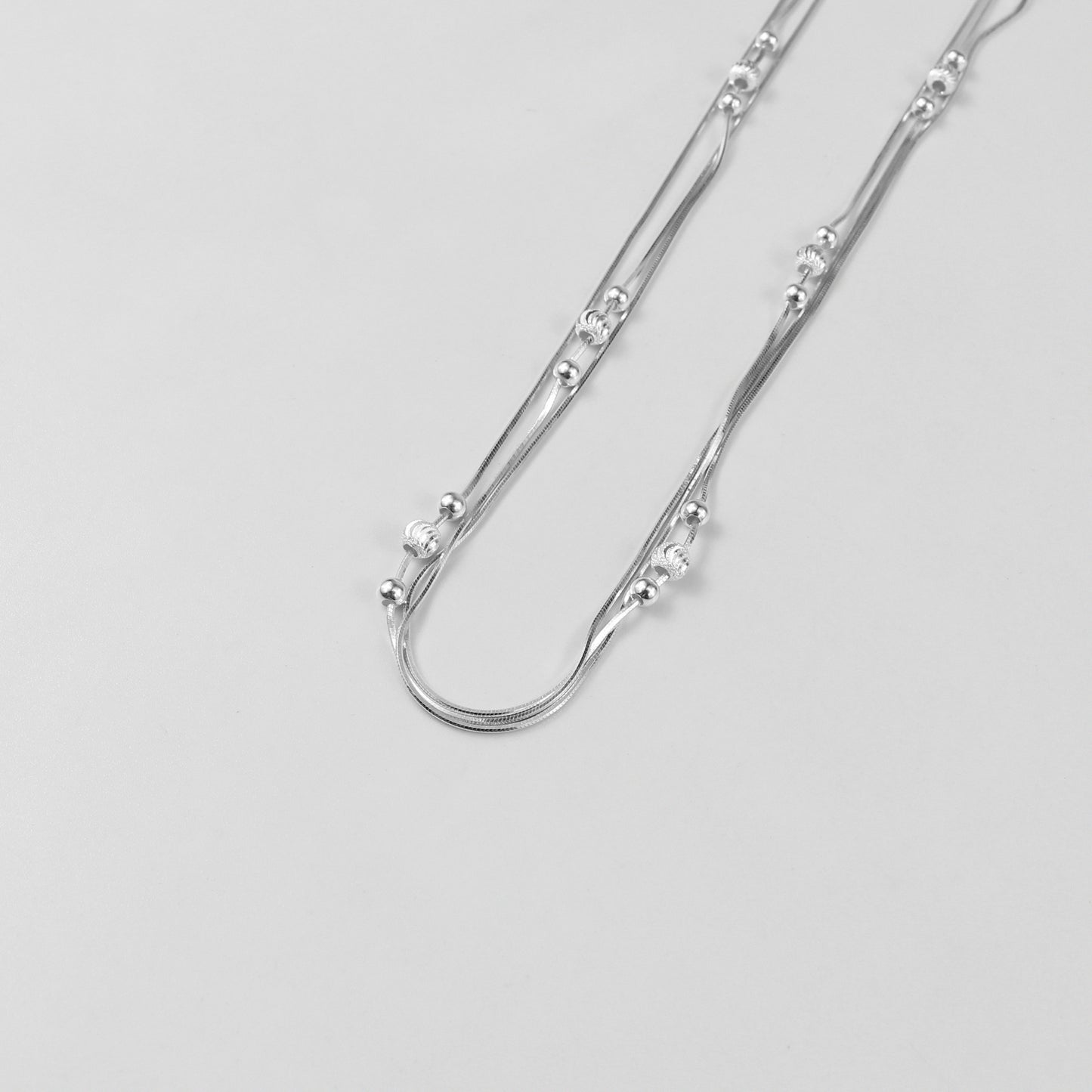 An elegant necklace named 'Trio Shine,' crafted from 925 sterling silver. Its design features three radiant elements that symbolize harmony, brilliance, and timeless sophistication.