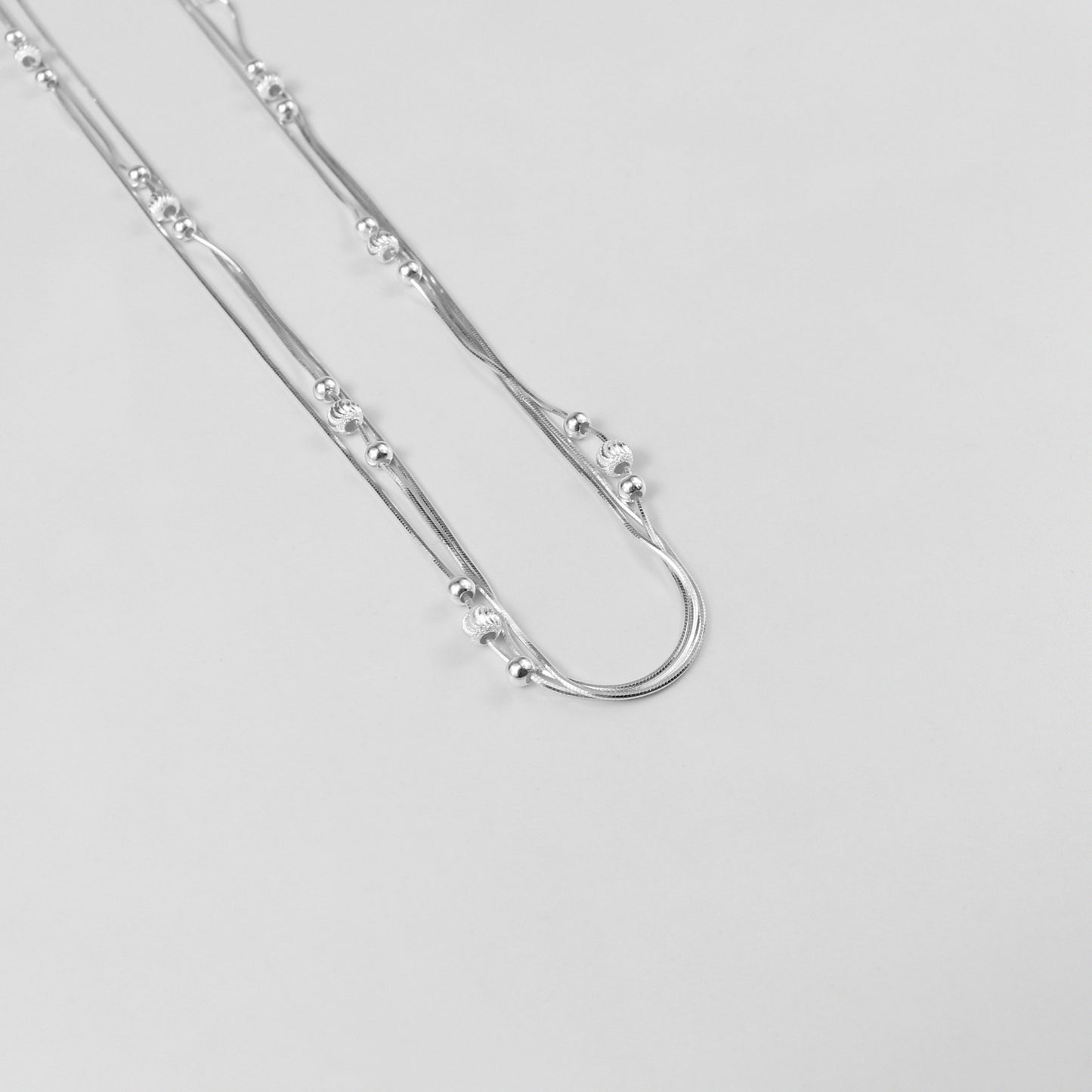 An elegant necklace named 'Trio Shine,' crafted from 925 sterling silver. Its design features three radiant elements that symbolize harmony, brilliance, and timeless sophistication.