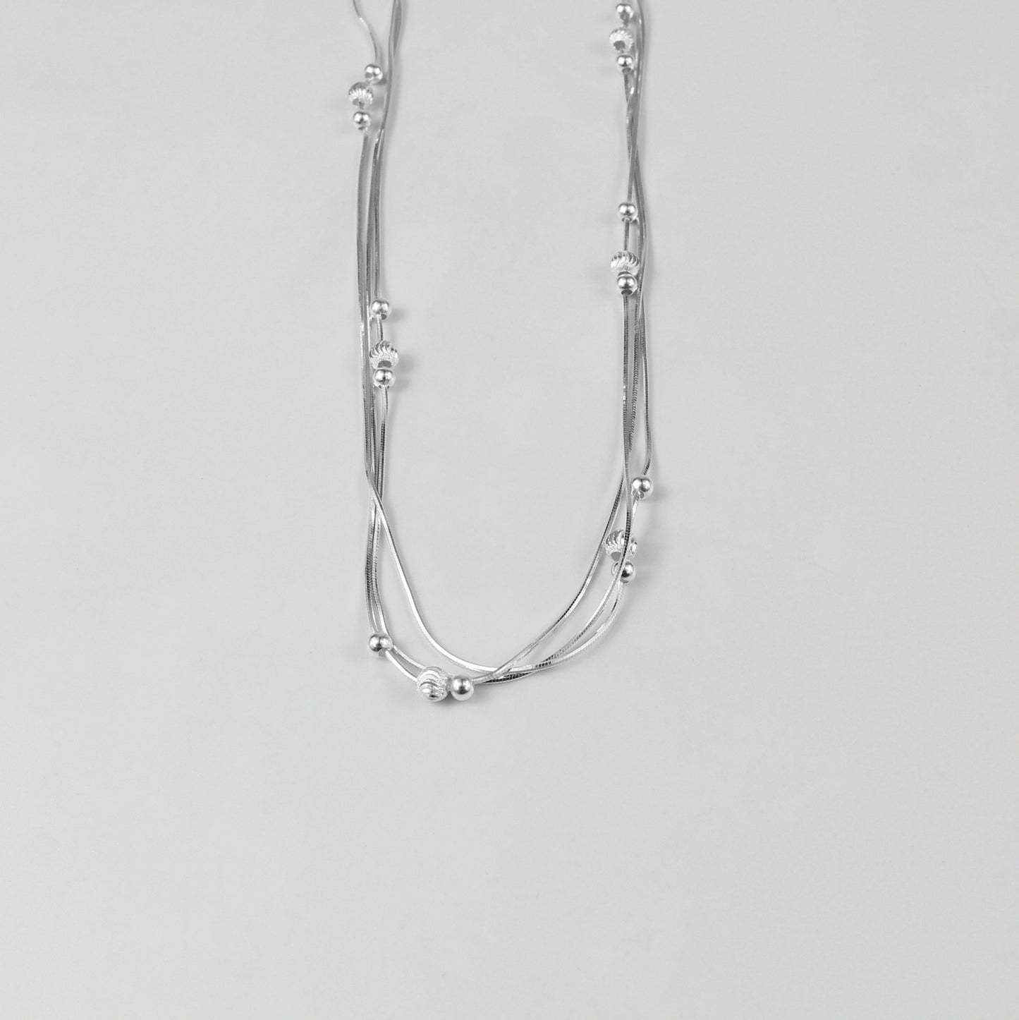 An elegant necklace named 'Trio Shine,' crafted from 925 sterling silver. Its design features three radiant elements that symbolize harmony, brilliance, and timeless sophistication.