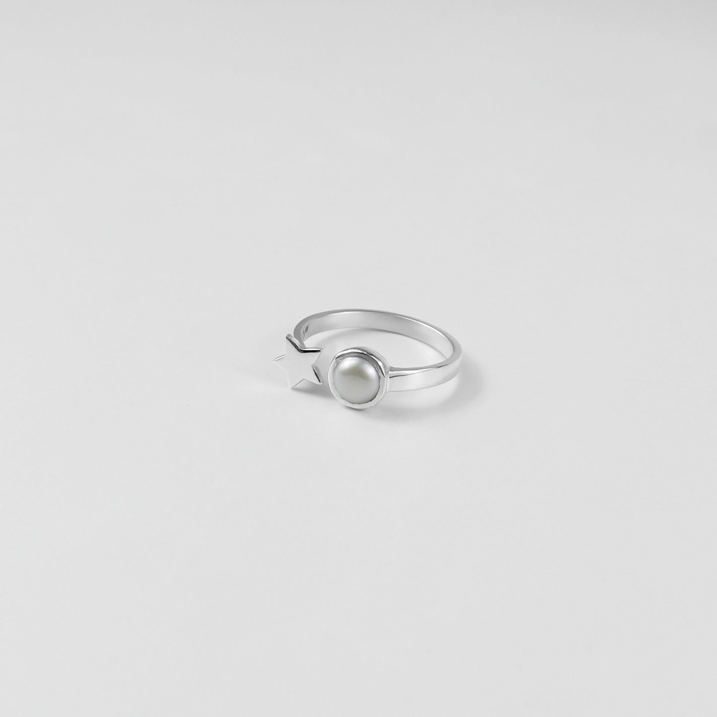 "925 sterling silver ring featuring a star and pearl design, offering a touch of elegance and charm, named 'Star & Pearl Ring.'"