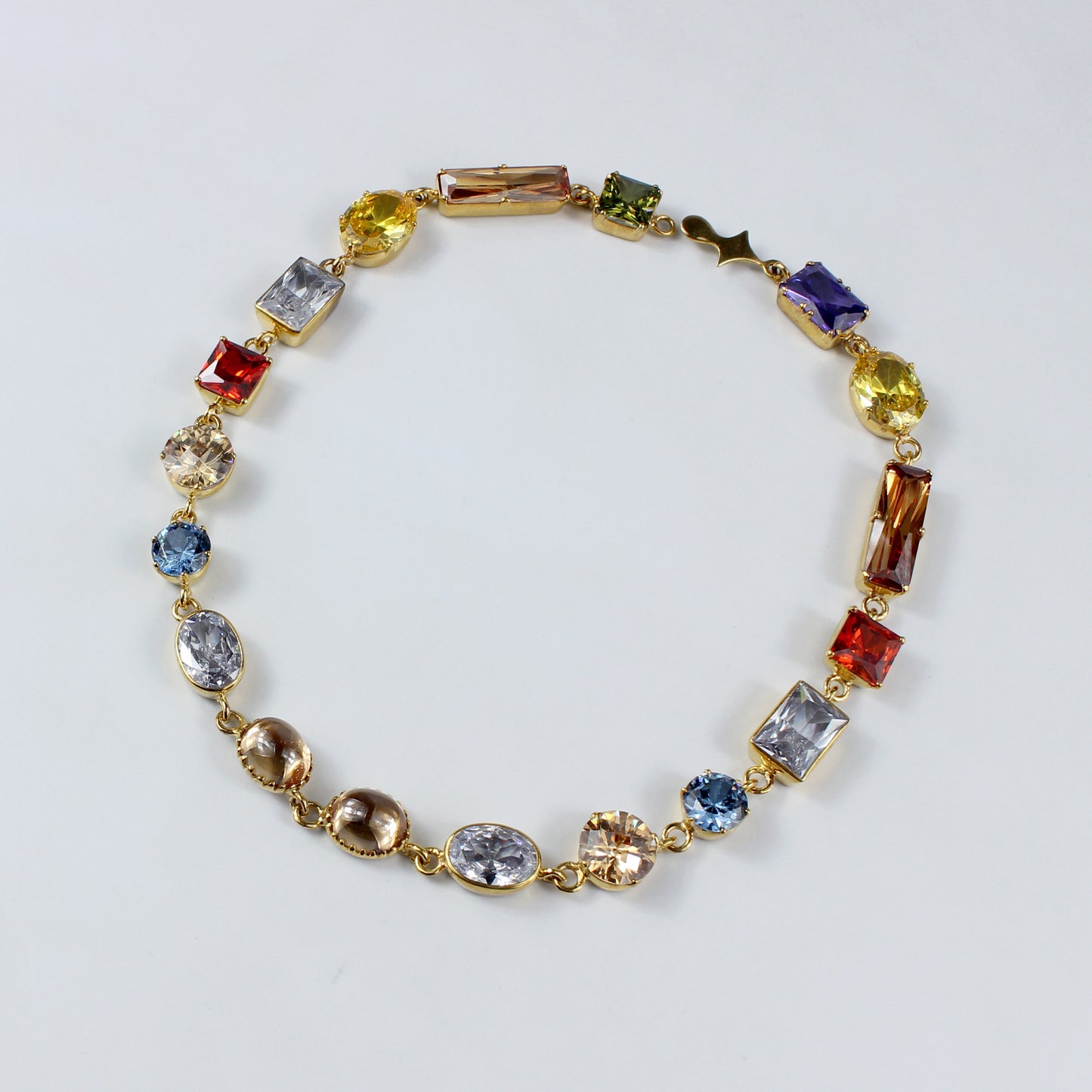 An elegant brass necklace plated with 18k gold, adorned with a dazzling gemstone centerpiece. This timeless piece combines luxurious materials with a classic design, perfect for adding a touch of sophistication to any outfit.