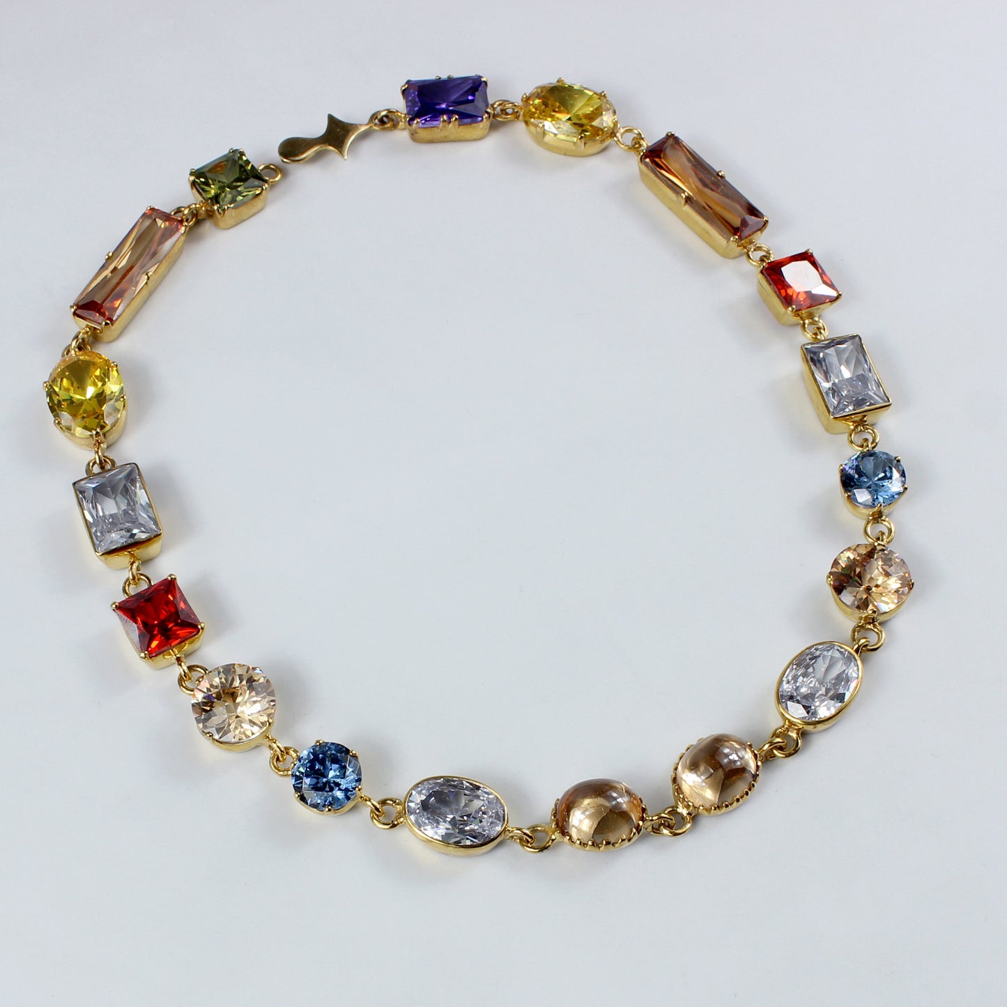 An elegant brass necklace plated with 18k gold, adorned with a dazzling gemstone centerpiece. This timeless piece combines luxurious materials with a classic design, perfect for adding a touch of sophistication to any outfit.