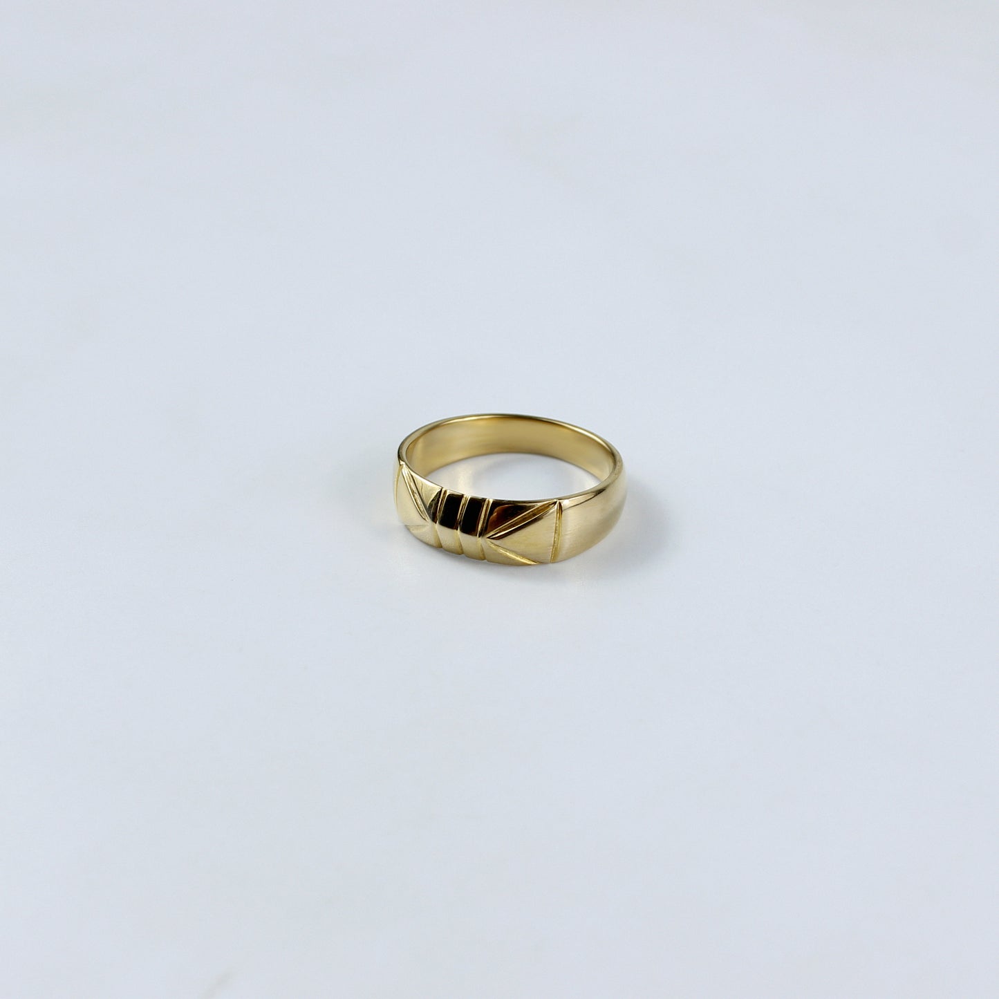 A sleek brass band ring plated with 18k gold, featuring a radiant polished finish that exudes timeless elegance. This versatile piece is perfect for adding a touch of luxury to any outfit, from casual to formal.