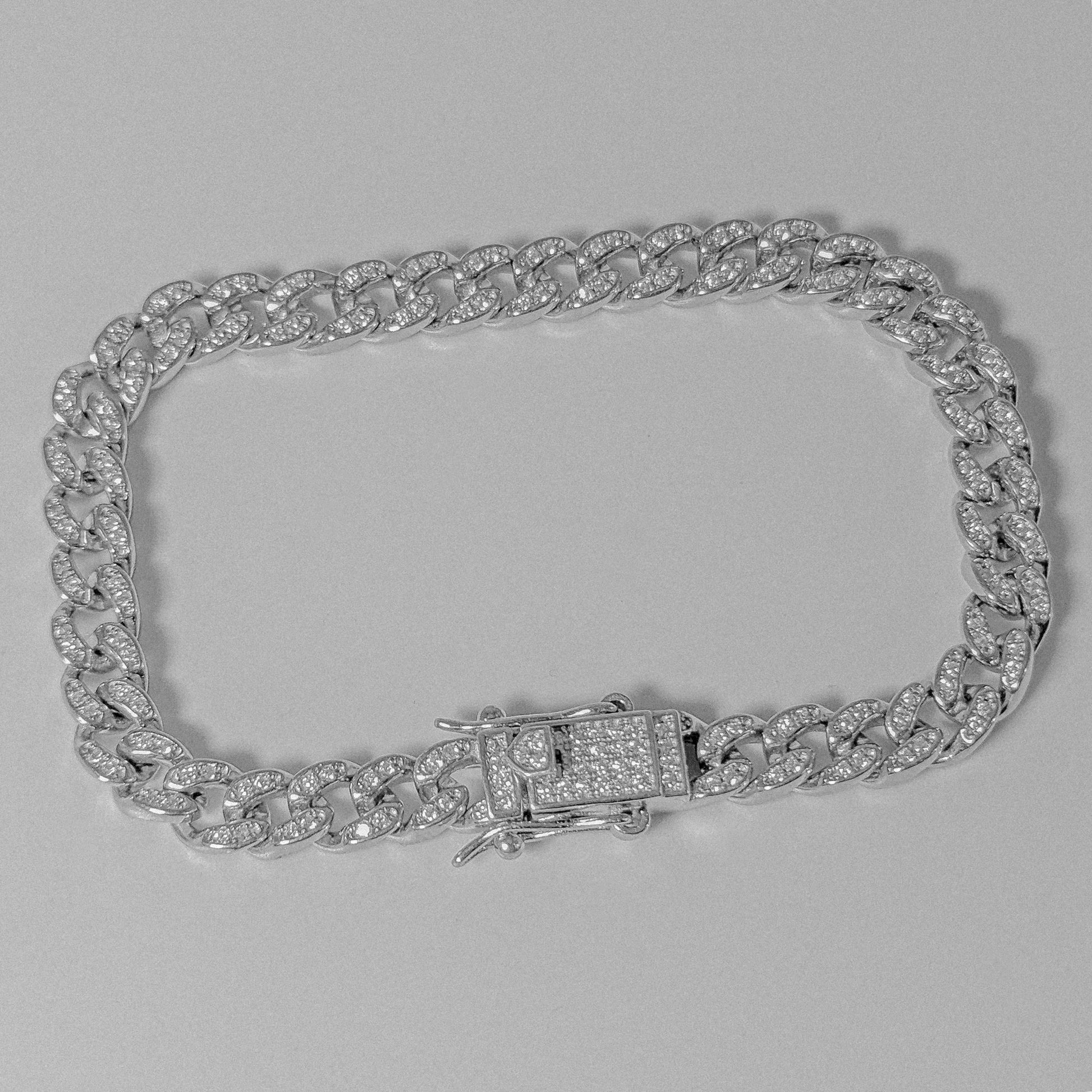 Iced Out Cuban Link Bracelet - A luxurious 925 sterling silver bracelet by GetTheJuice, featuring sparkling stones embedded in a robust Cuban link design that exudes elegance and glamour.