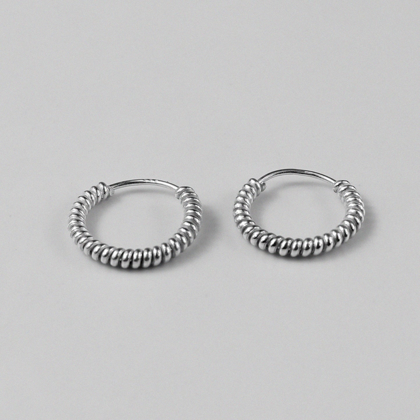 Twist Hoop Earrings - An exquisite pair of 925 sterling silver earrings by GetTheJuice, with a beautifully twisted design that combines classic hoops with a fresh, elegant twist.