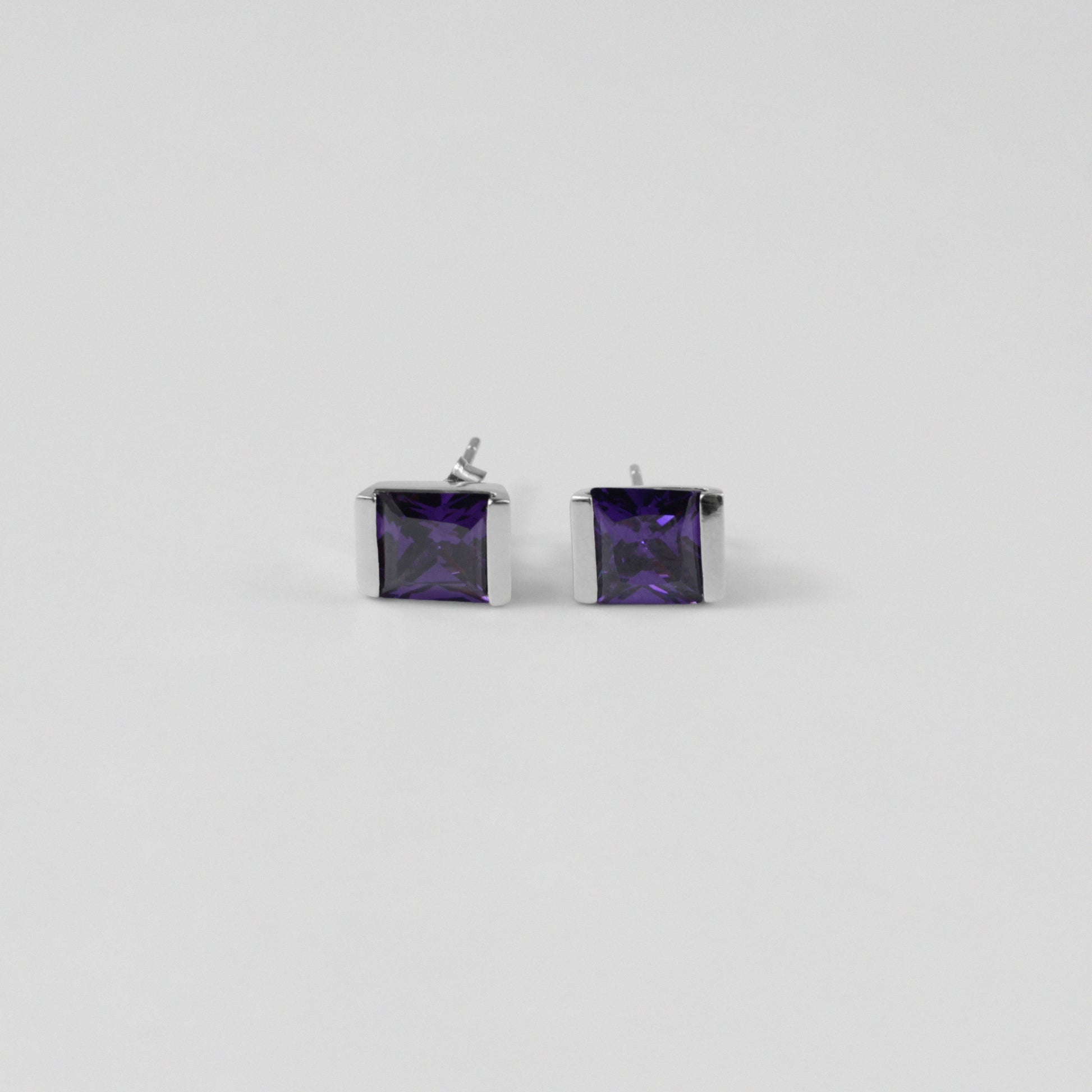 Violet Gleam Ear Studs - A stunning pair of 925 sterling silver ear studs by GetTheJuice, showcasing a sparkling violet hue that enhances any ensemble with a pop of vibrant elegance.