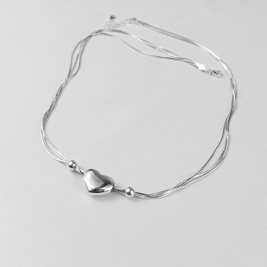 An elegant necklace named 'Heartstrings,' crafted from 925 sterling silver. Its design features delicate, intertwining strands that symbolize connection, love, and timeless beauty.