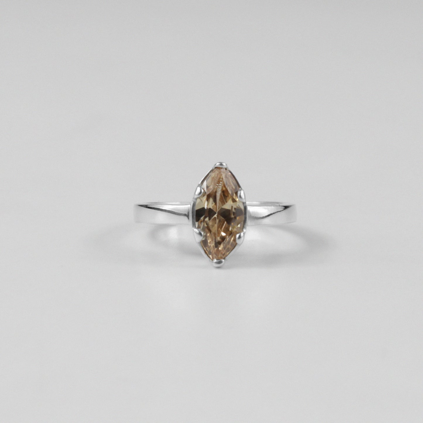 Sterling silver ring stamped '925,' featuring a glowing amber-colored gemstone centerpiece.