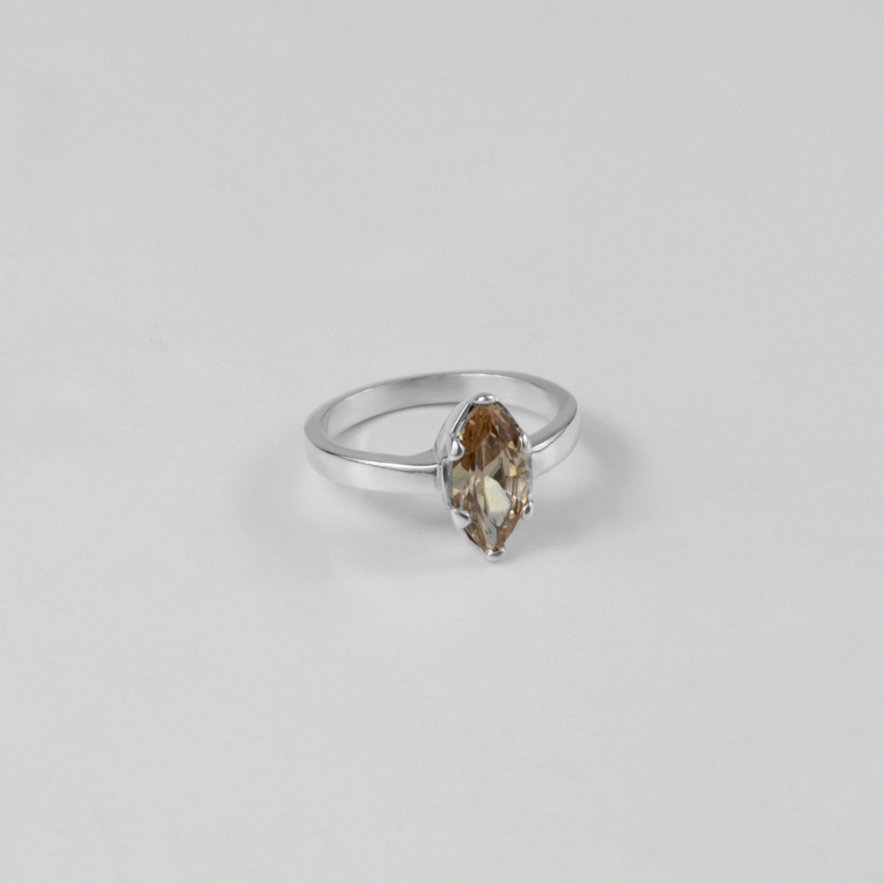 Sterling silver ring stamped '925,' featuring a glowing amber-colored gemstone centerpiece.