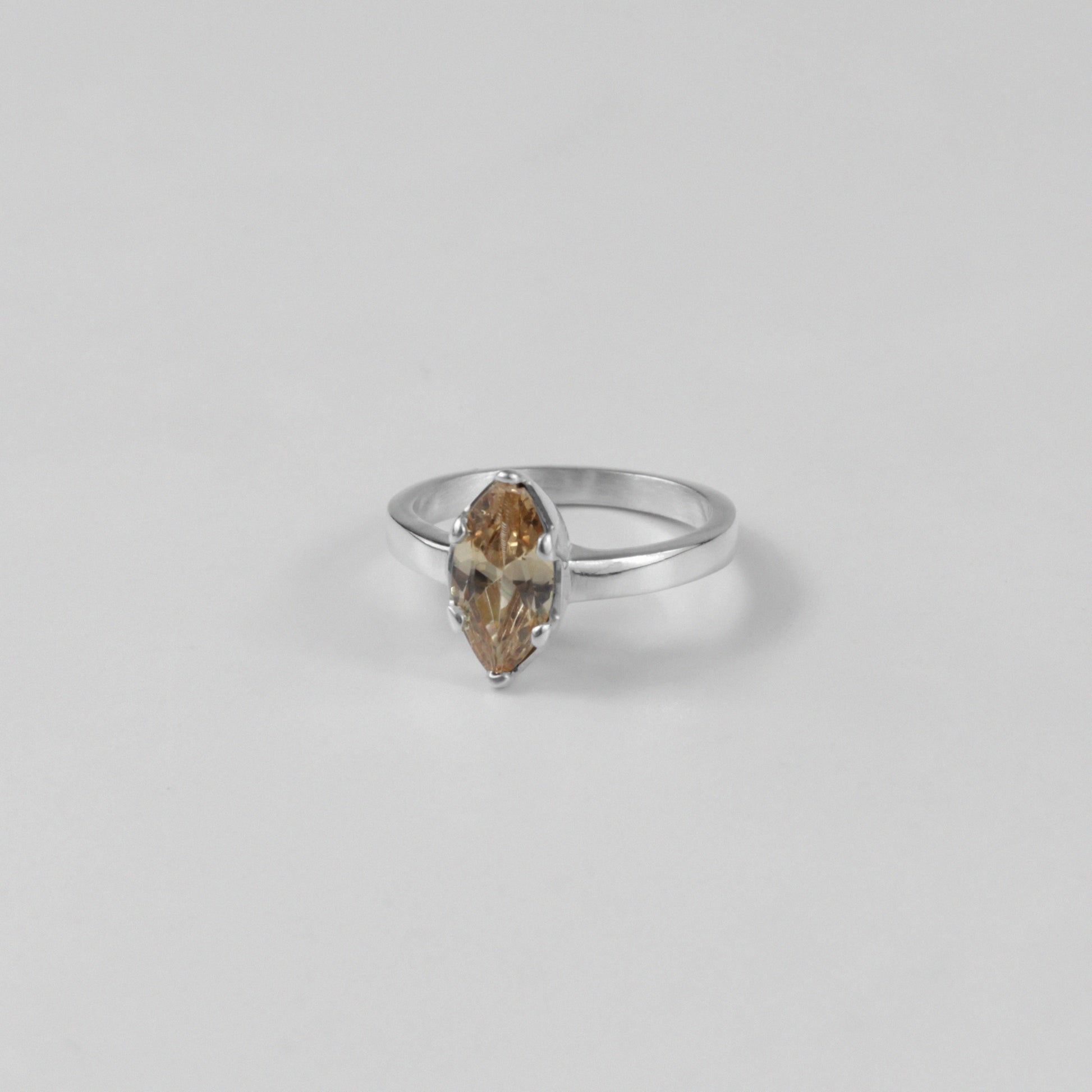 Sterling silver ring stamped '925,' featuring a glowing amber-colored gemstone centerpiece.