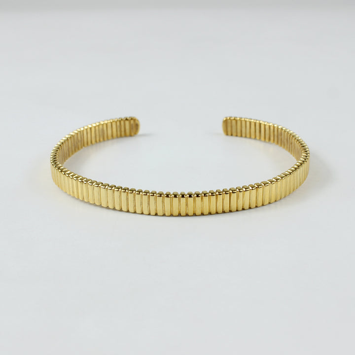 A stunning cuff bracelet crafted from brass and plated with 18k gold, radiating a warm golden glow. This sleek and sophisticated piece combines bold design with timeless elegance, perfect for making a statement.