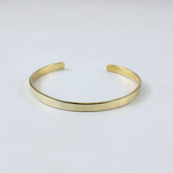 An exquisite brass cuff plated with 18k gold, designed with clean lines and a high-shine finish. This LuxeCuff Bracelet embodies modern glamour and sophistication.