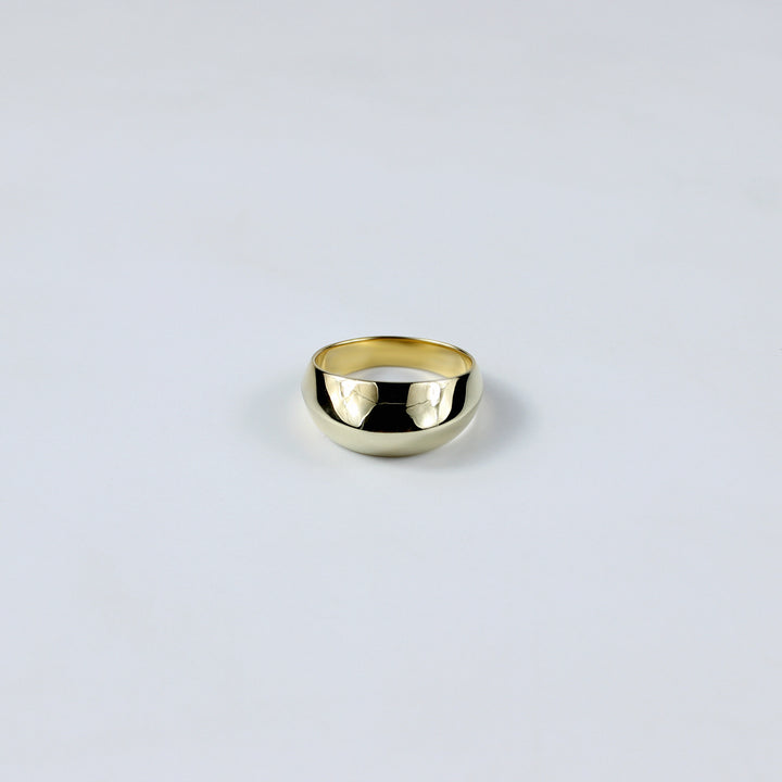An eye-catching brass ring plated with 18k gold, featuring a bold and dynamic design that radiates charm and confidence. This striking accessory blends contemporary style with timeless elegance, making it a perfect statement piece.