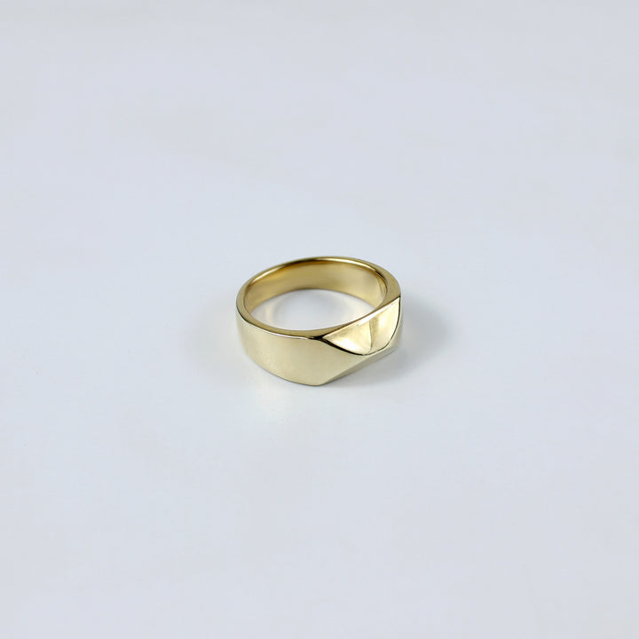 A refined ring crafted from brass and plated with 18k gold, showcasing a unique grip-inspired design. This modern and luxurious piece adds a touch of bold elegance, perfect for making a stylish statement.