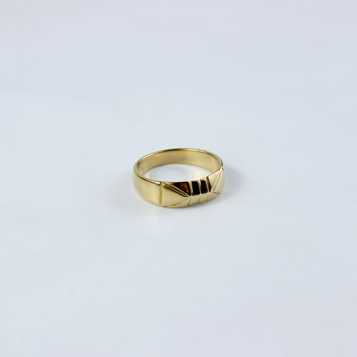 A sleek brass band ring plated with 18k gold, featuring a radiant polished finish that exudes timeless elegance. This versatile piece is perfect for adding a touch of luxury to any outfit, from casual to formal.